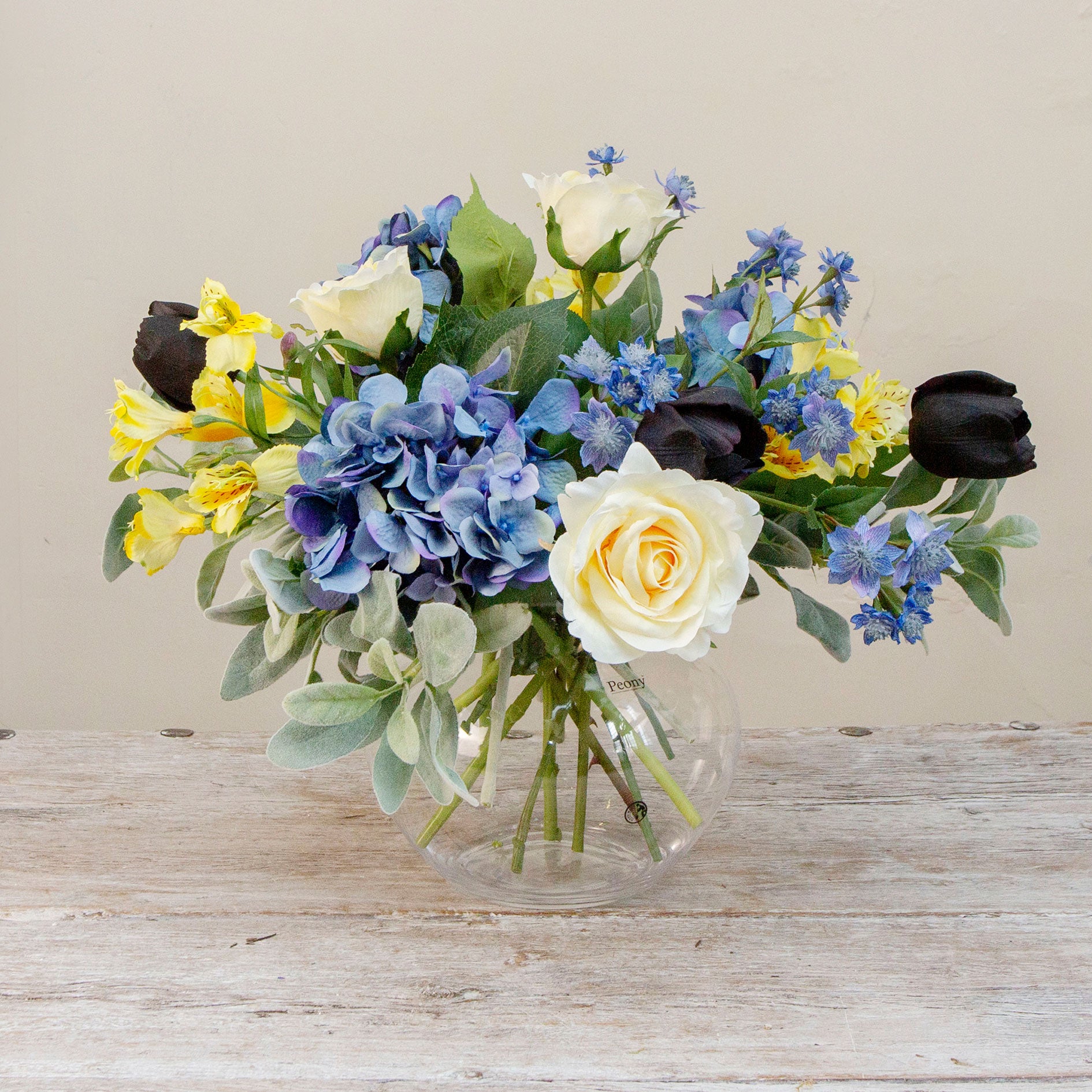 Artificial blue and yellow floral bowl arrangement with Roses, Hydrangeas and Tulips