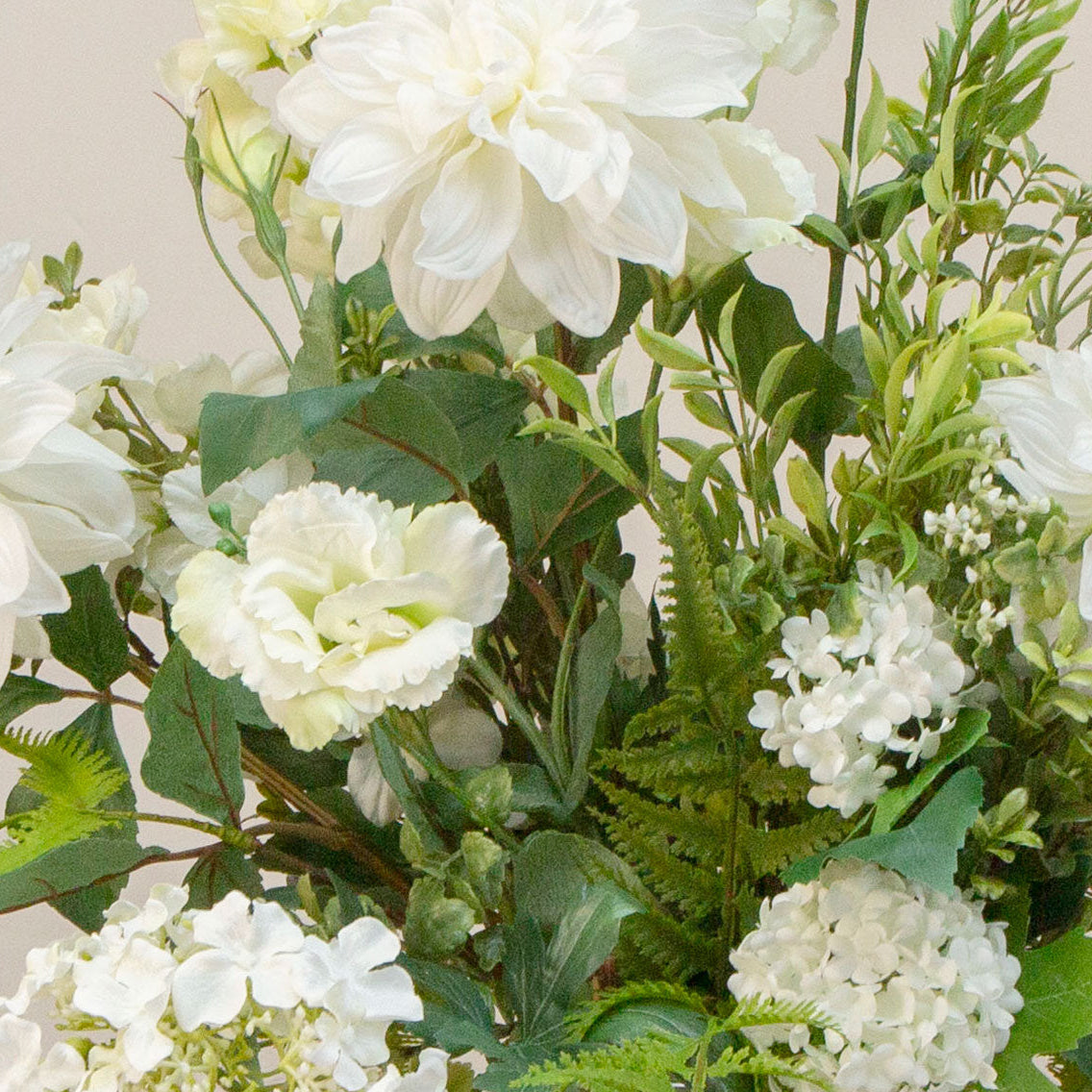 Artificial white and greenery faux flower arrangement with hydrangea, dahlia, snowball blooms and ferns in a glass Hampton vase