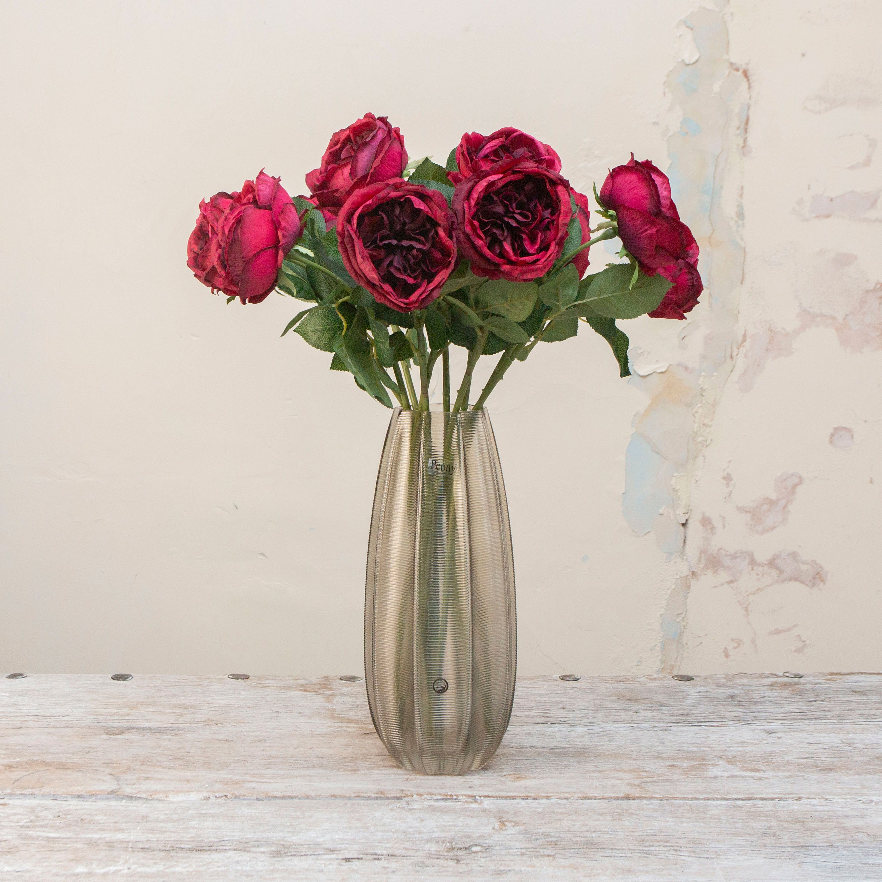 Artificial deep wine-red rose stems displayed in a vase, showcasing a full burgundy rose bloom with natural colour depth and lifelike leaves