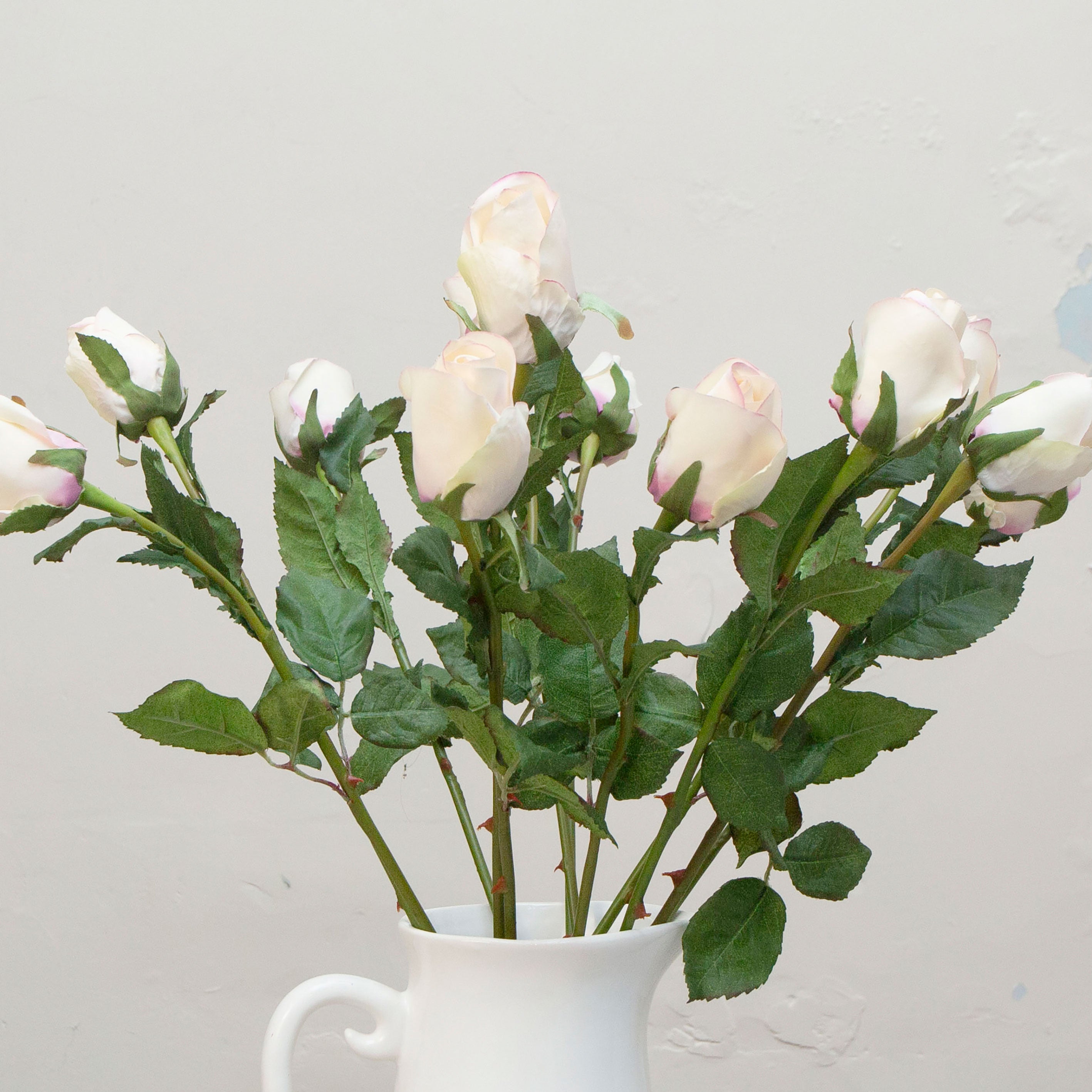 Close-up of artificial open rose buds showing soft blush and cream petals with natural colour variation