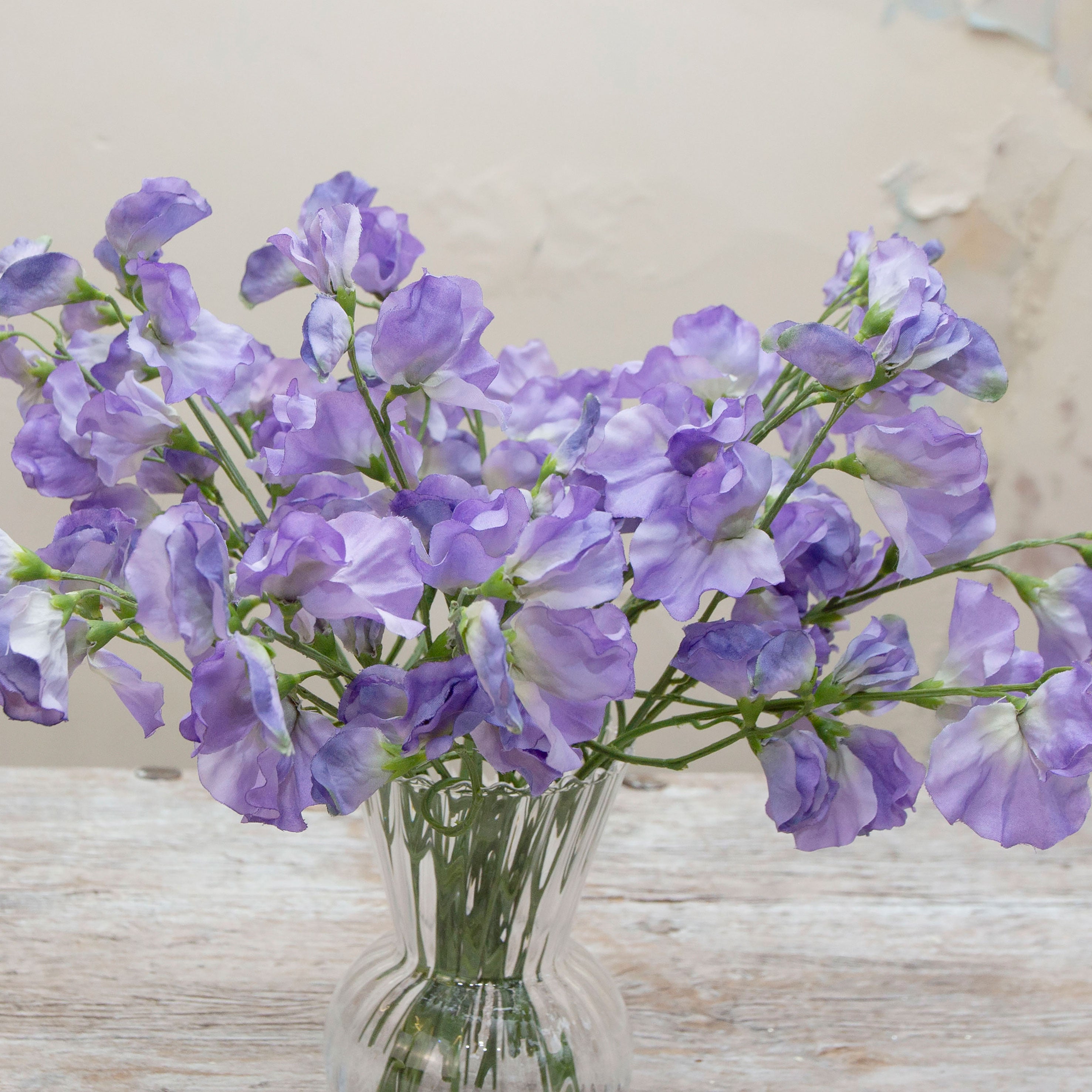 Close-up of artificial lavender-blue sweet pea flowers showing soft petals and gentle purple colour variation