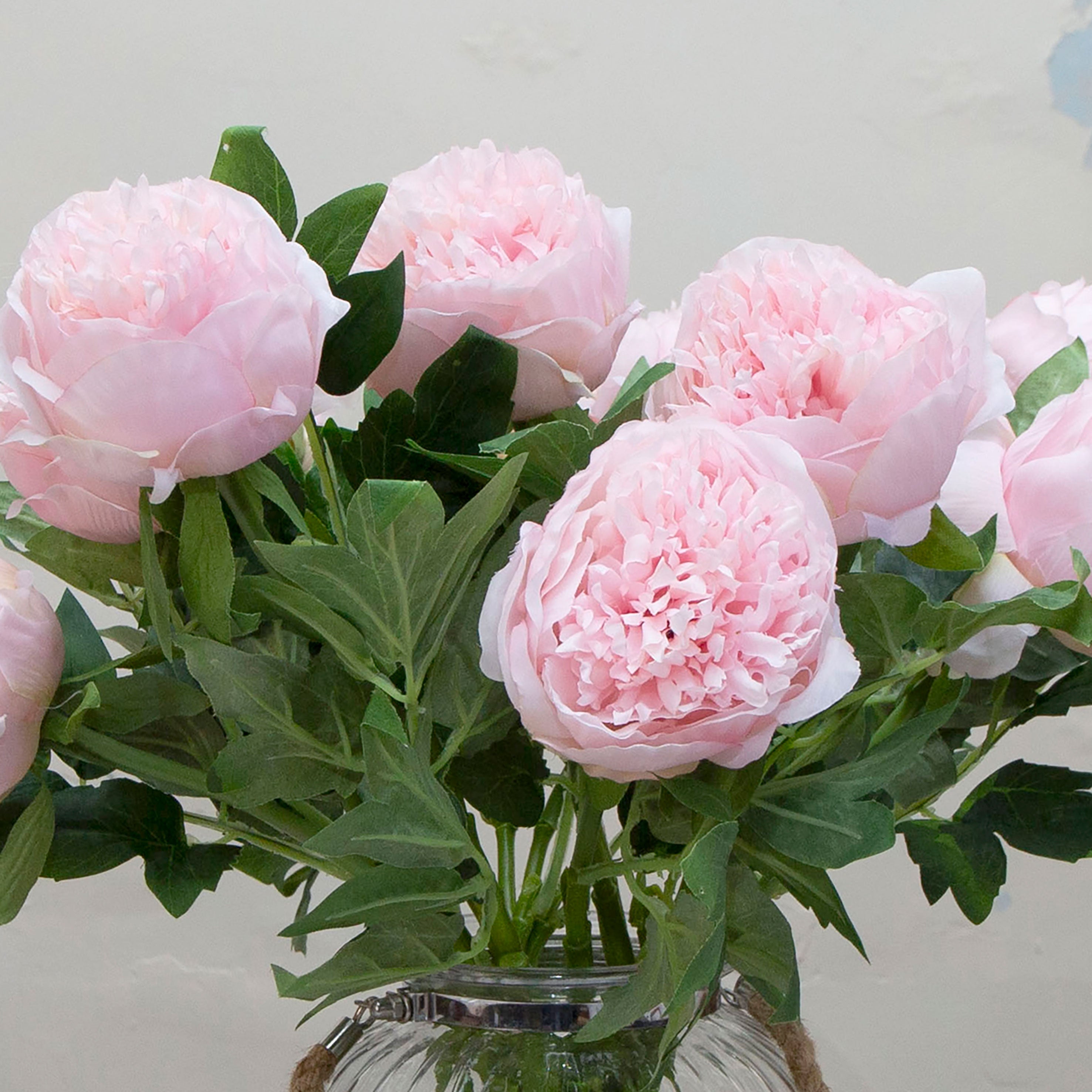 Close-up of artificial pale pink peony flowers, showing densely layered petals, soft blush tones and natural texture