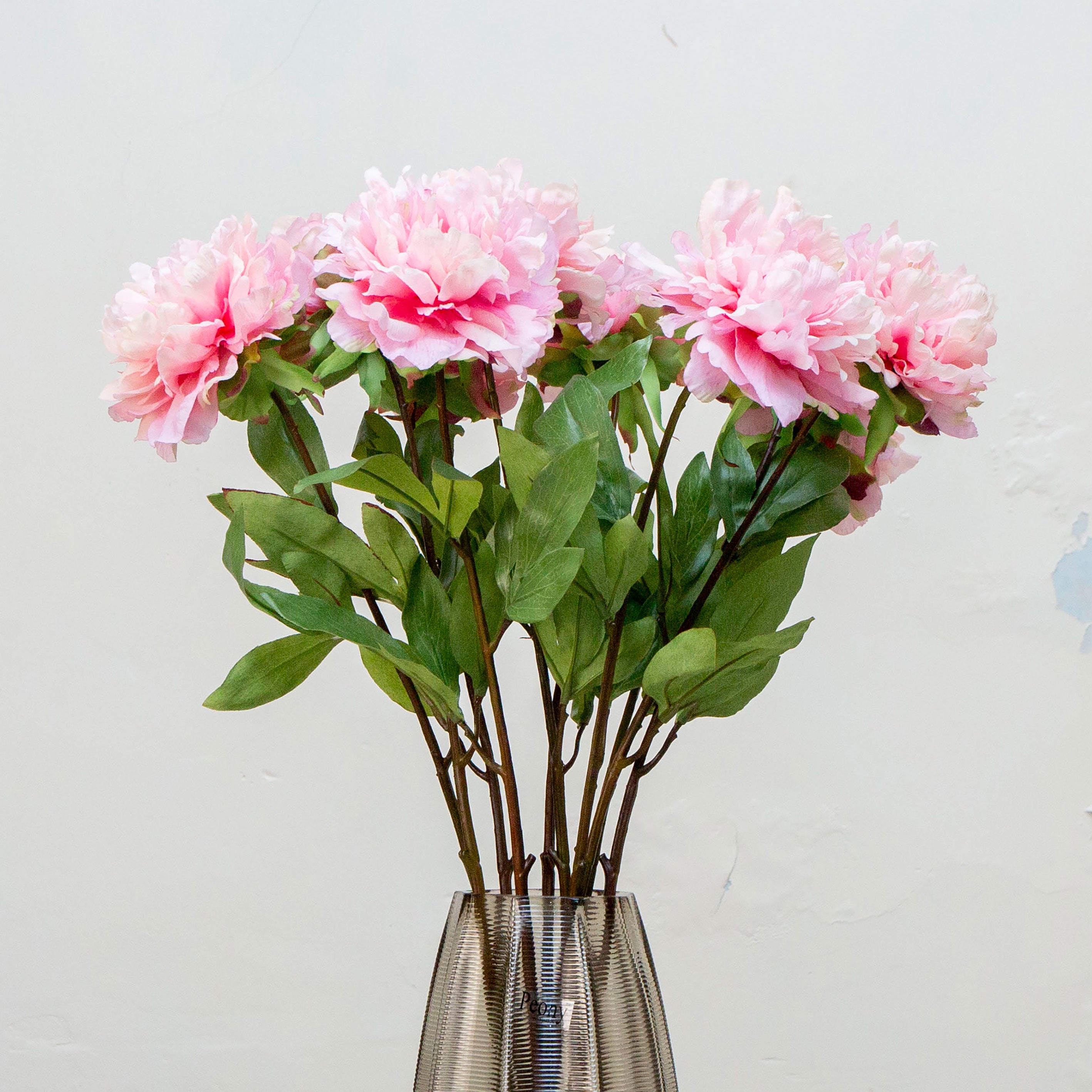 Close-up of artificial pale pink peony flower showing layered petals and soft colour variation