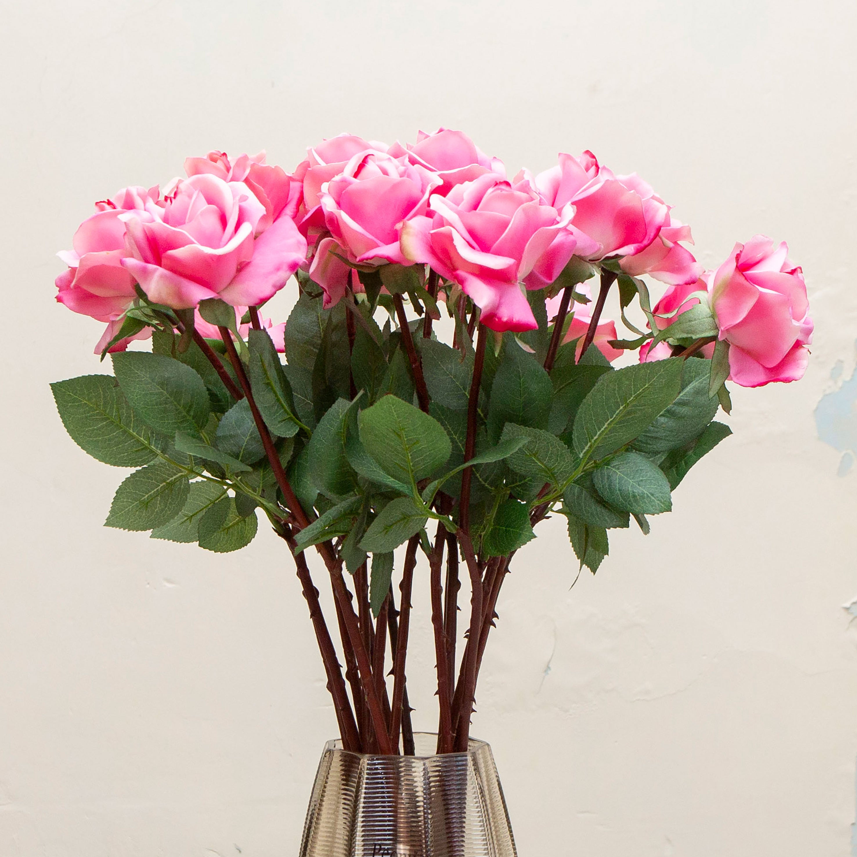 Close-up of artificial rose flower, showing vivid pink layered petals with soft shaping and realistic texture