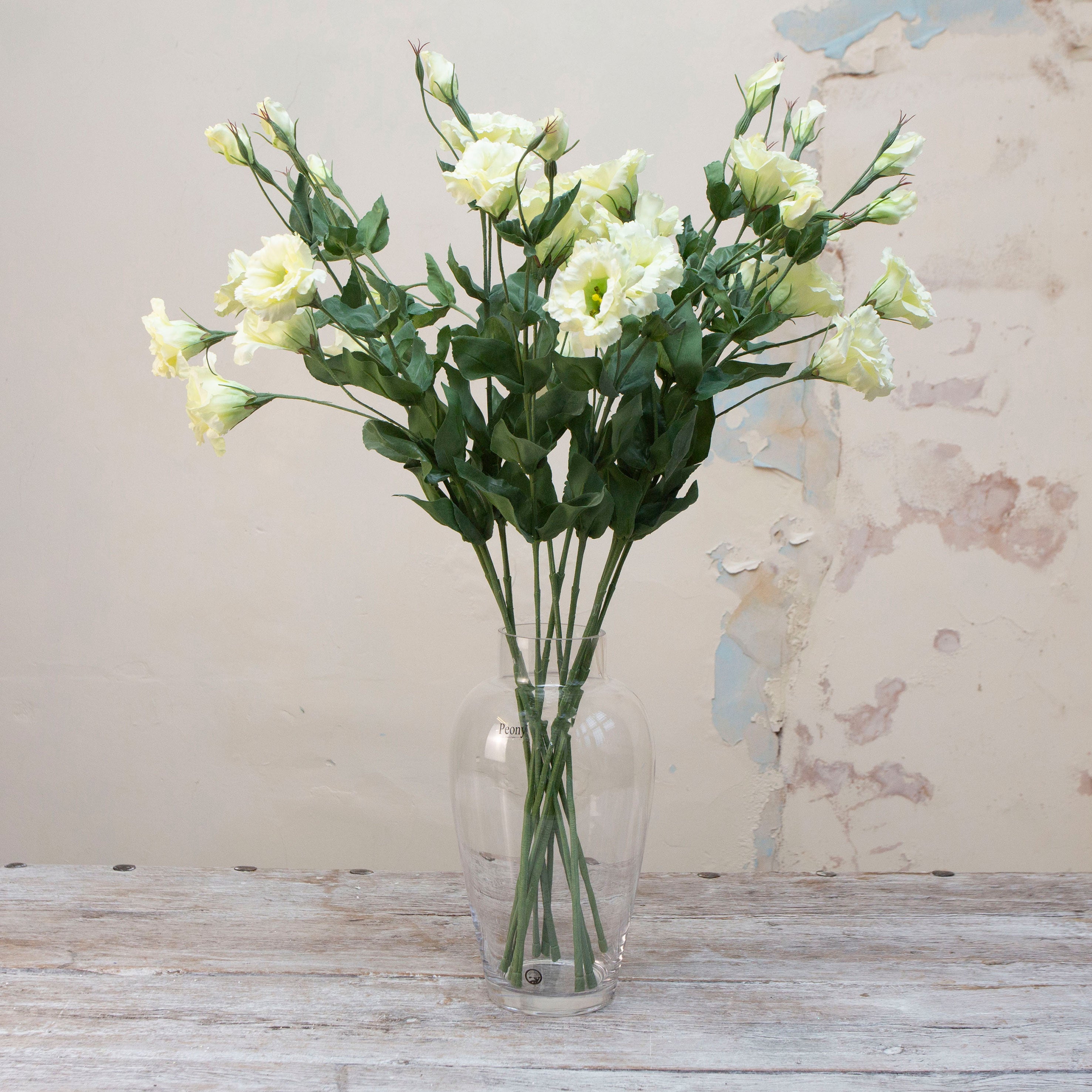 Artificial white lisianthus spray stems displayed together in a vase for styling purposes