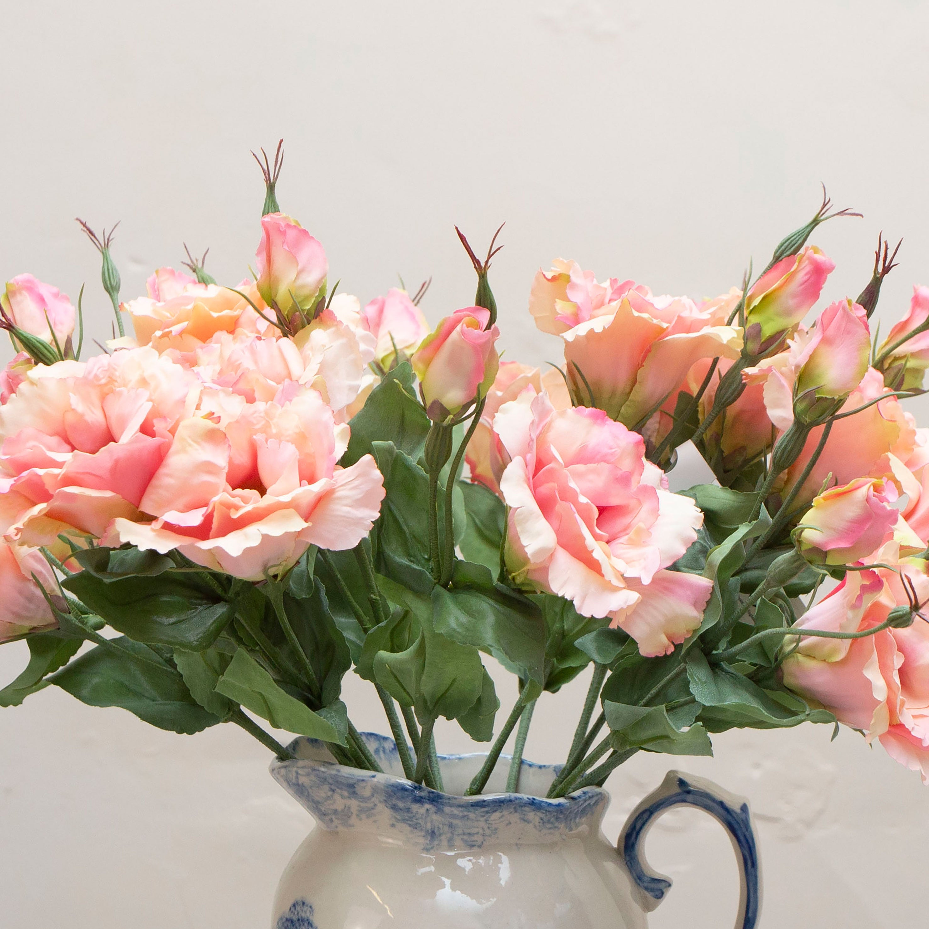 Close-up of artificial soft peach blush lisianthus flowers showing layered petals and delicate colour variation.