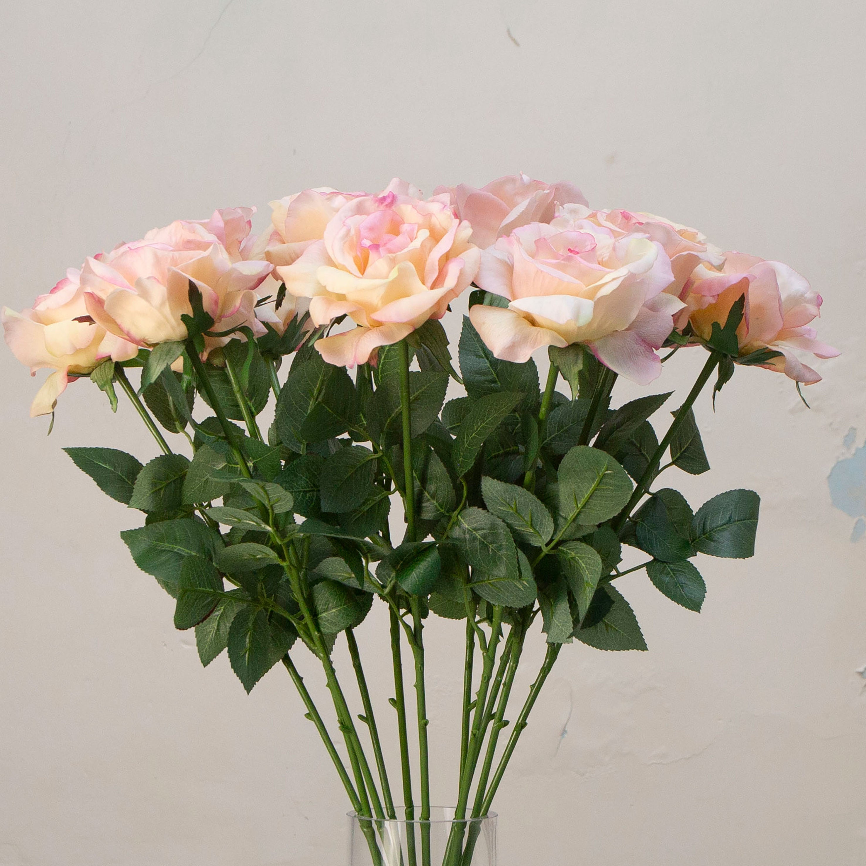 Close-up of artificial peach rose flower, highlighting soft peach petals with blush pink edging, delicate veining and realistic leaf texture.