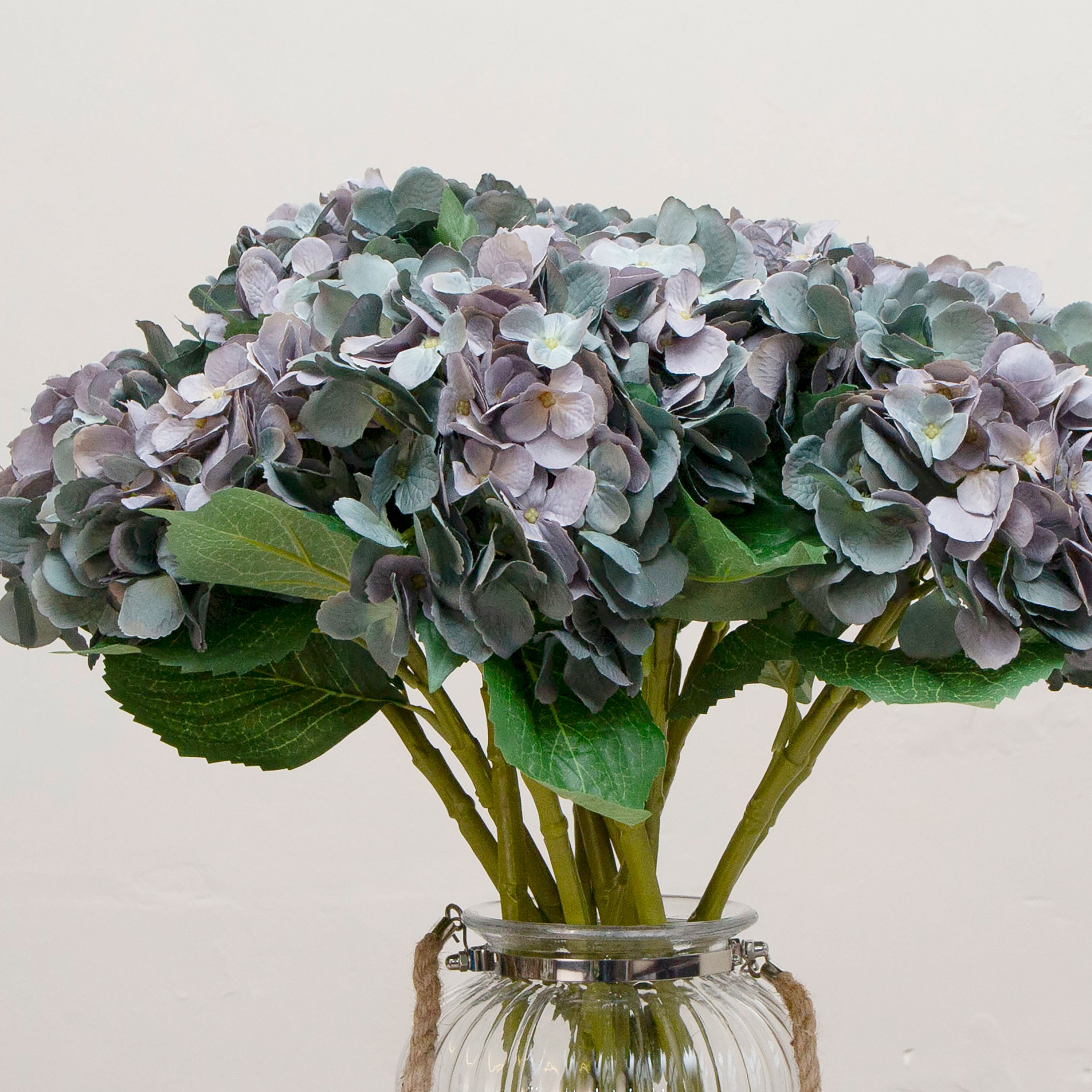 Close-up view of artificial hydrangea flowers showing layered blue-purple petals and delicate texture.
