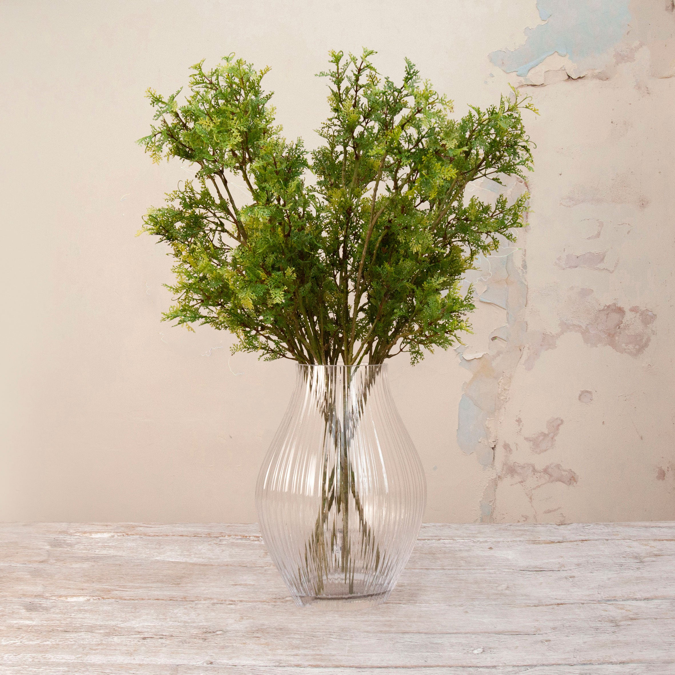 Artificial Autumnal Fern Foliage Stems with delicate green and yellow-toned foliage displayed in a clear ribbed glass vase