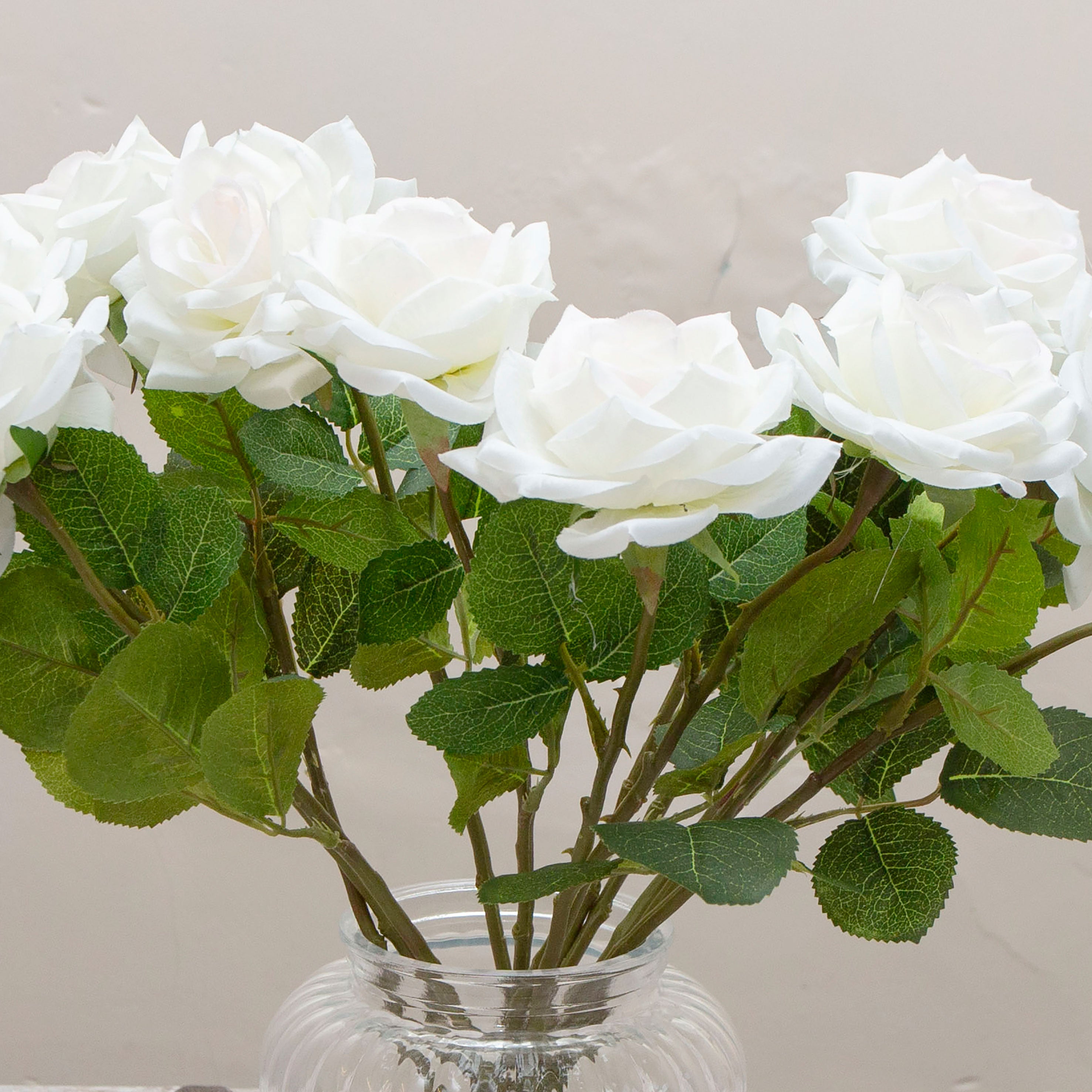 Close-up of artificial white rose flower showing layered petals and soft colour detail.