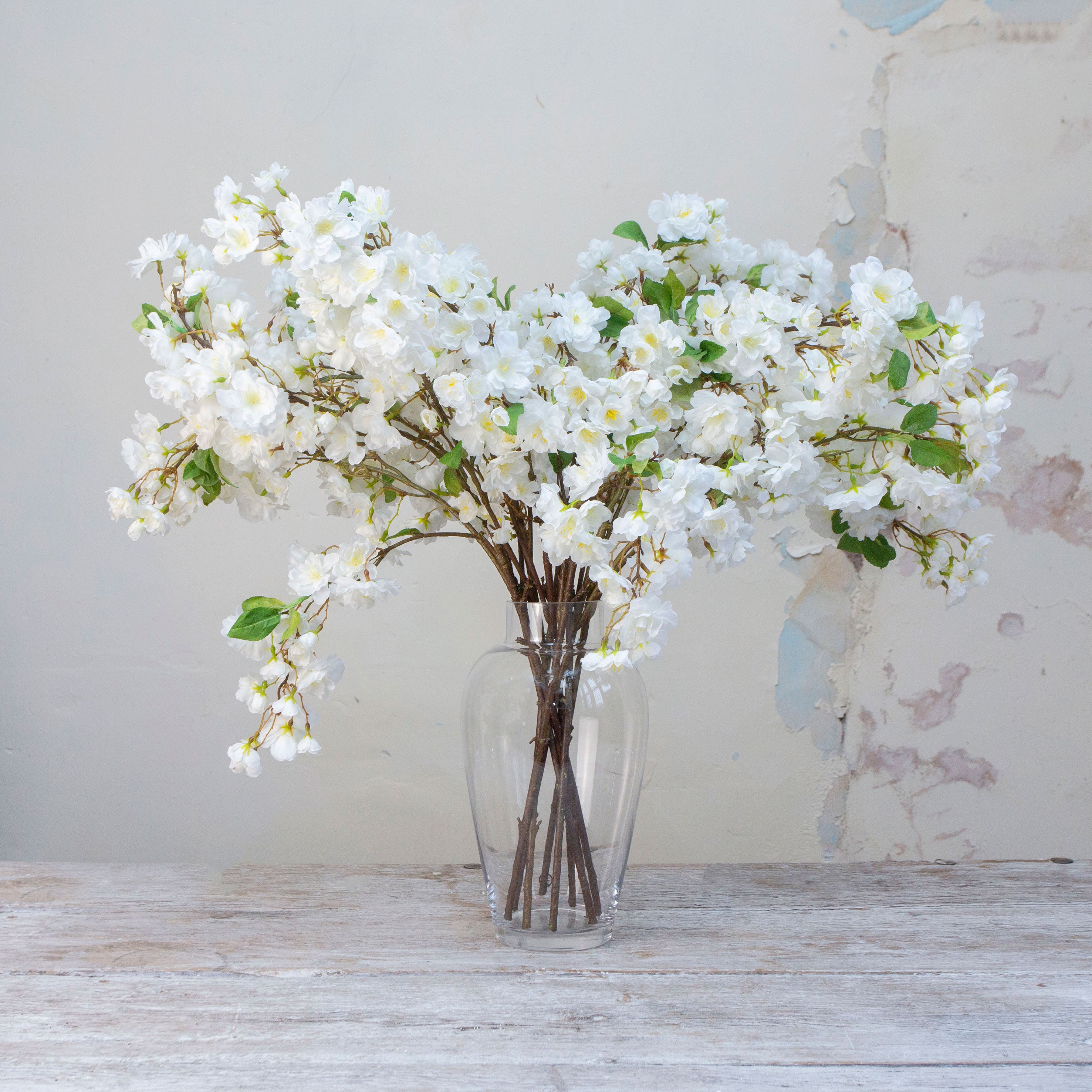 Artificial white cherry blossom stems displayed in vase