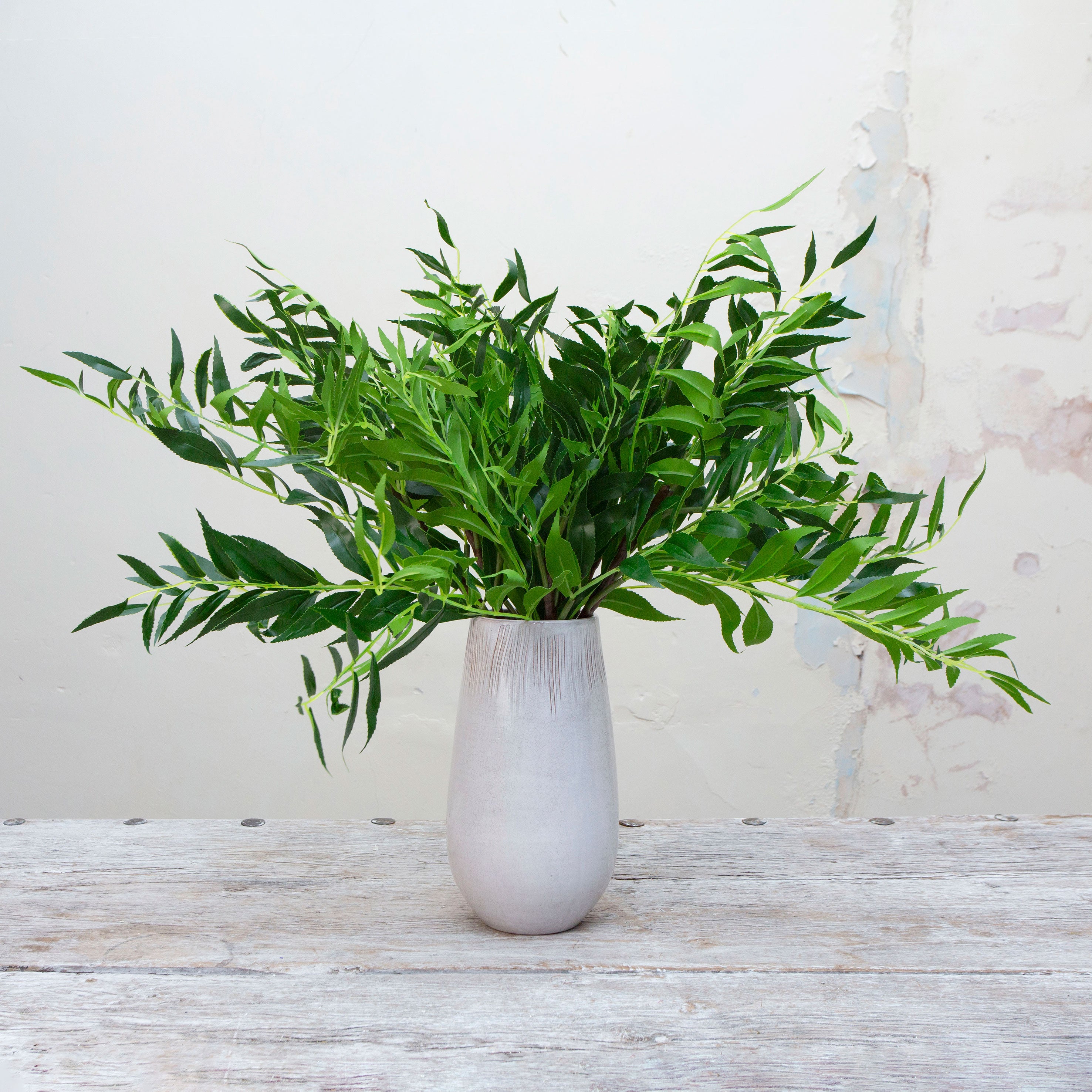 Artificial green Areca palm greenery displayed in a ceramic vase