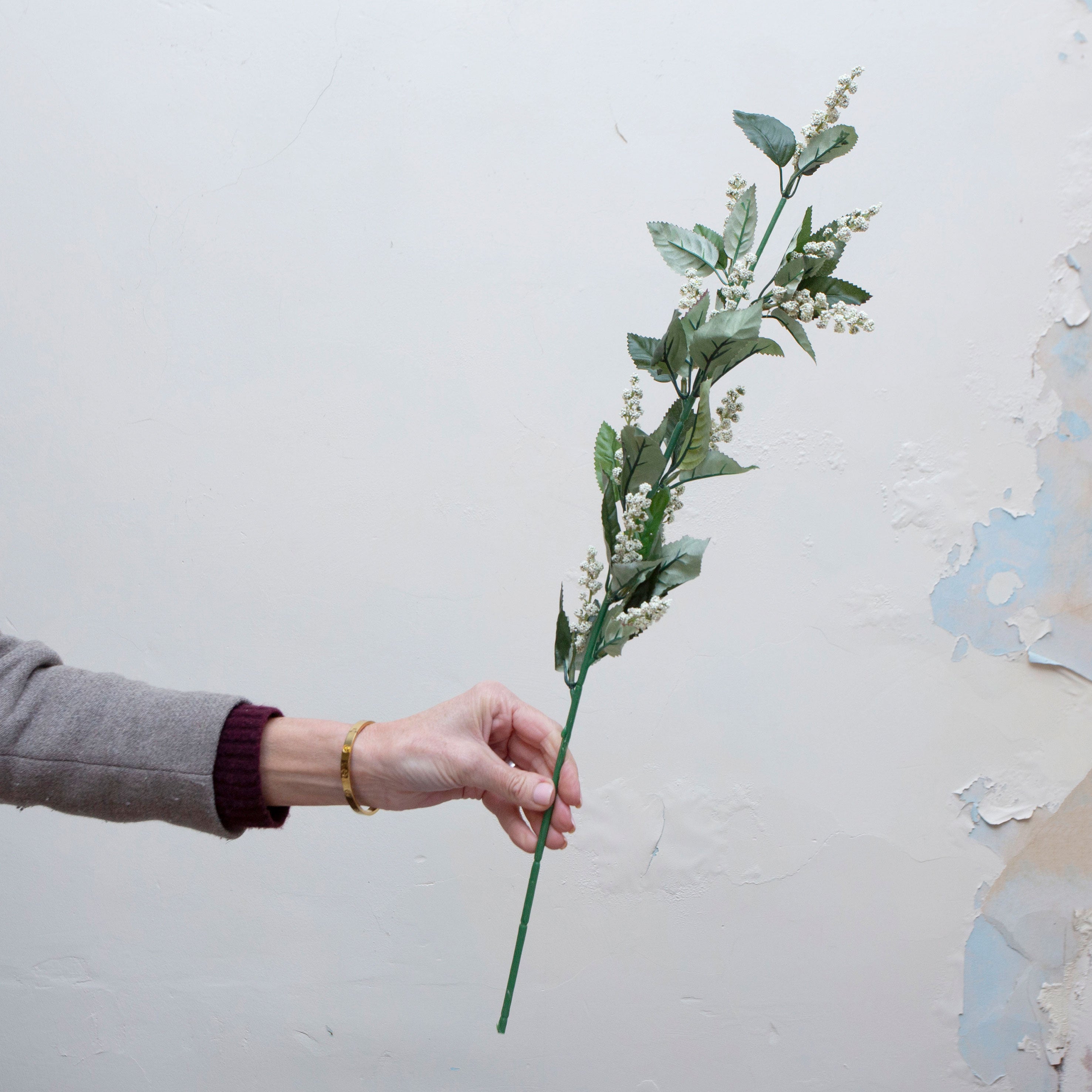Hand holding artificial astilbe stem