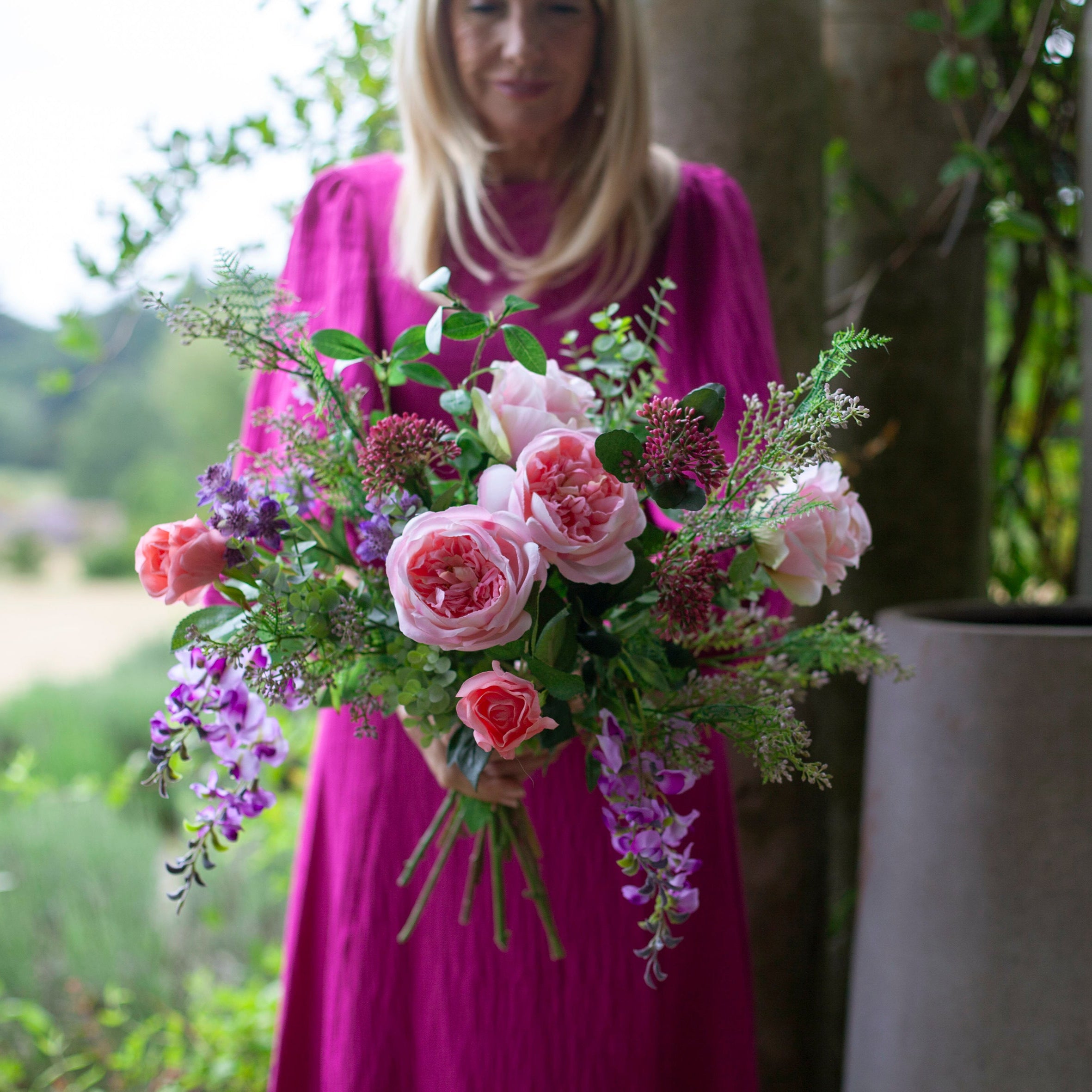 Artificial bouquet of pale pink roses, lavender wisteria, and astrantia with soft greenery,