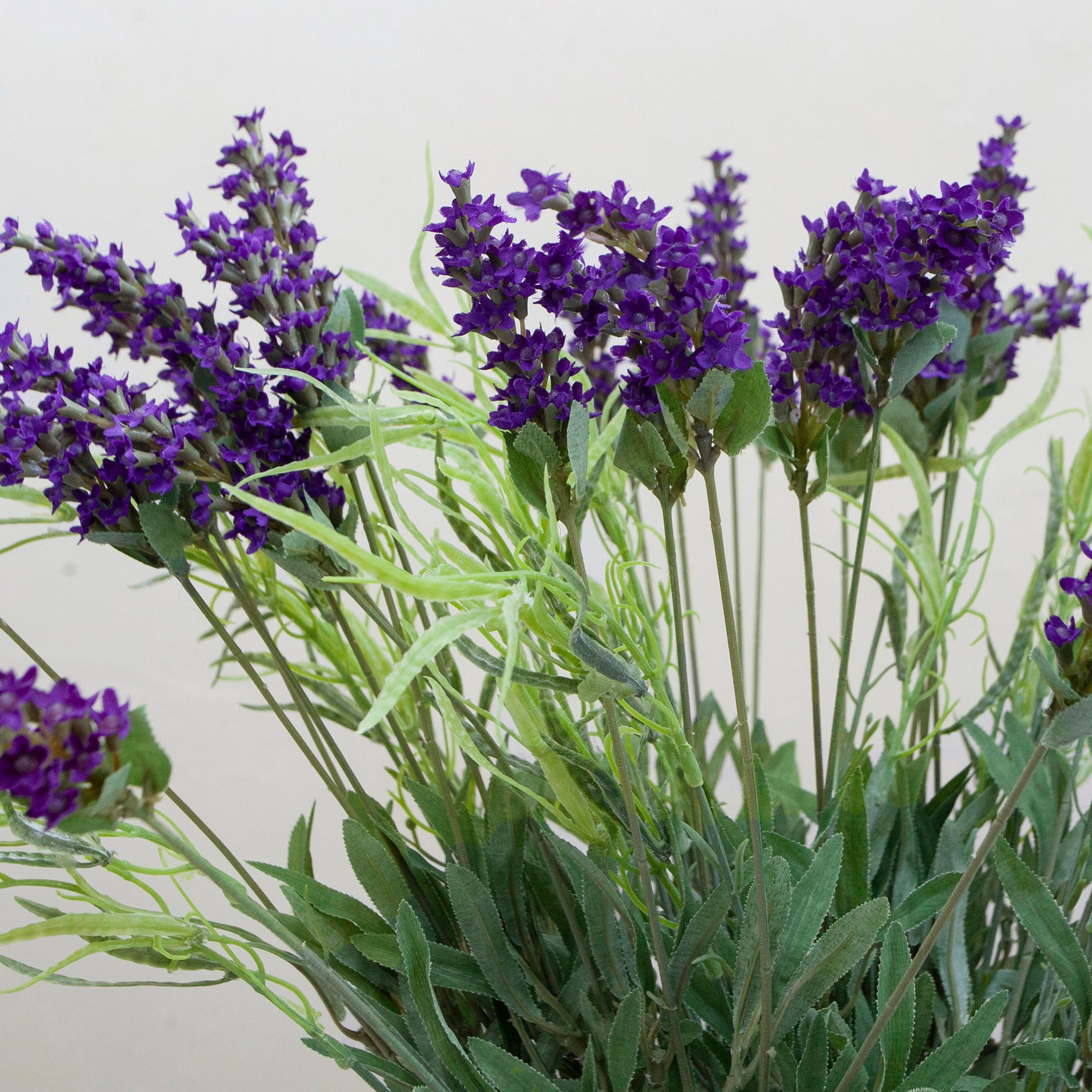 Artificial lavender arrangement with lifelike purple blooms and greenery, potted in a rustic bowl