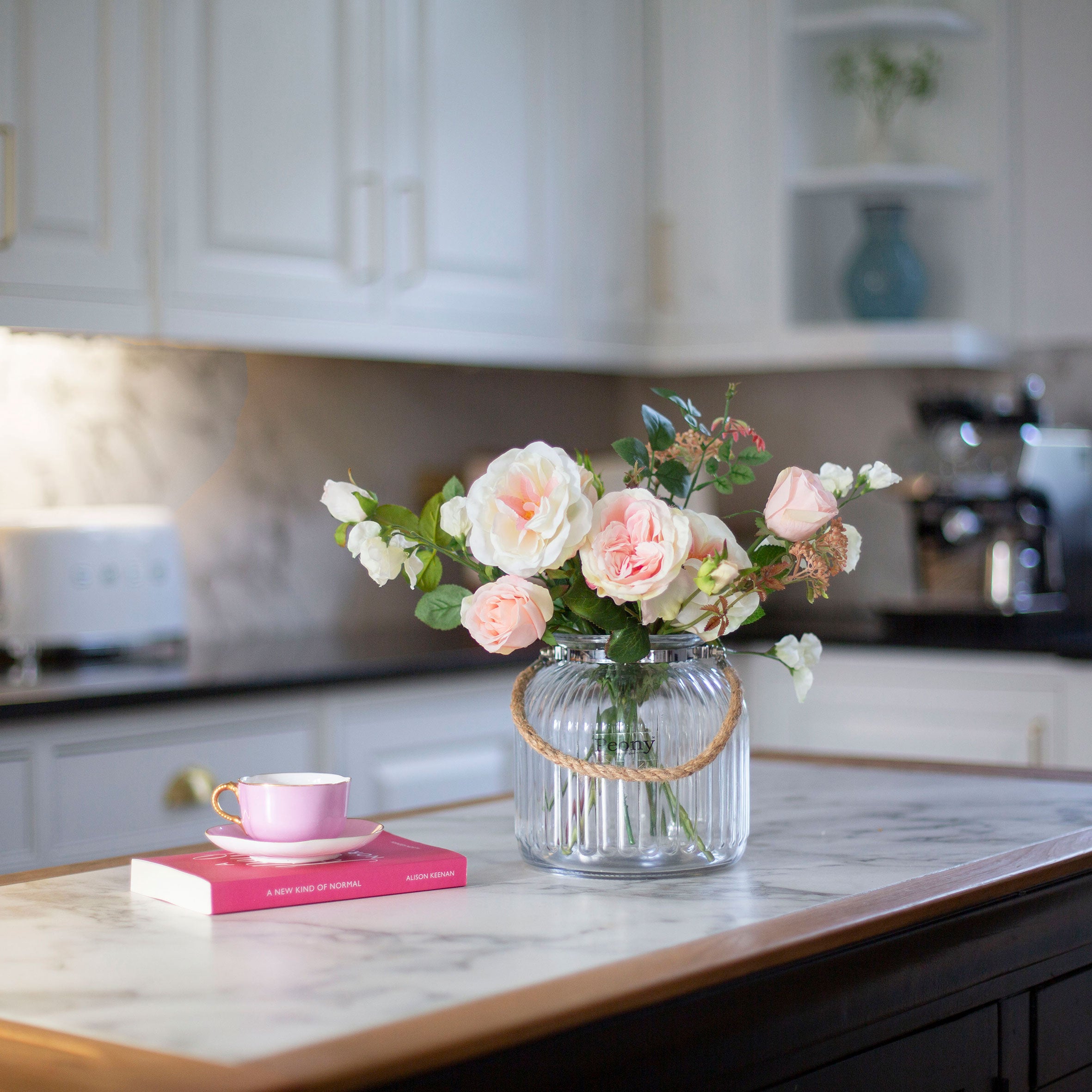 Artficial rose and sweet pea arrangement in a ribbed glass rope lantern vase