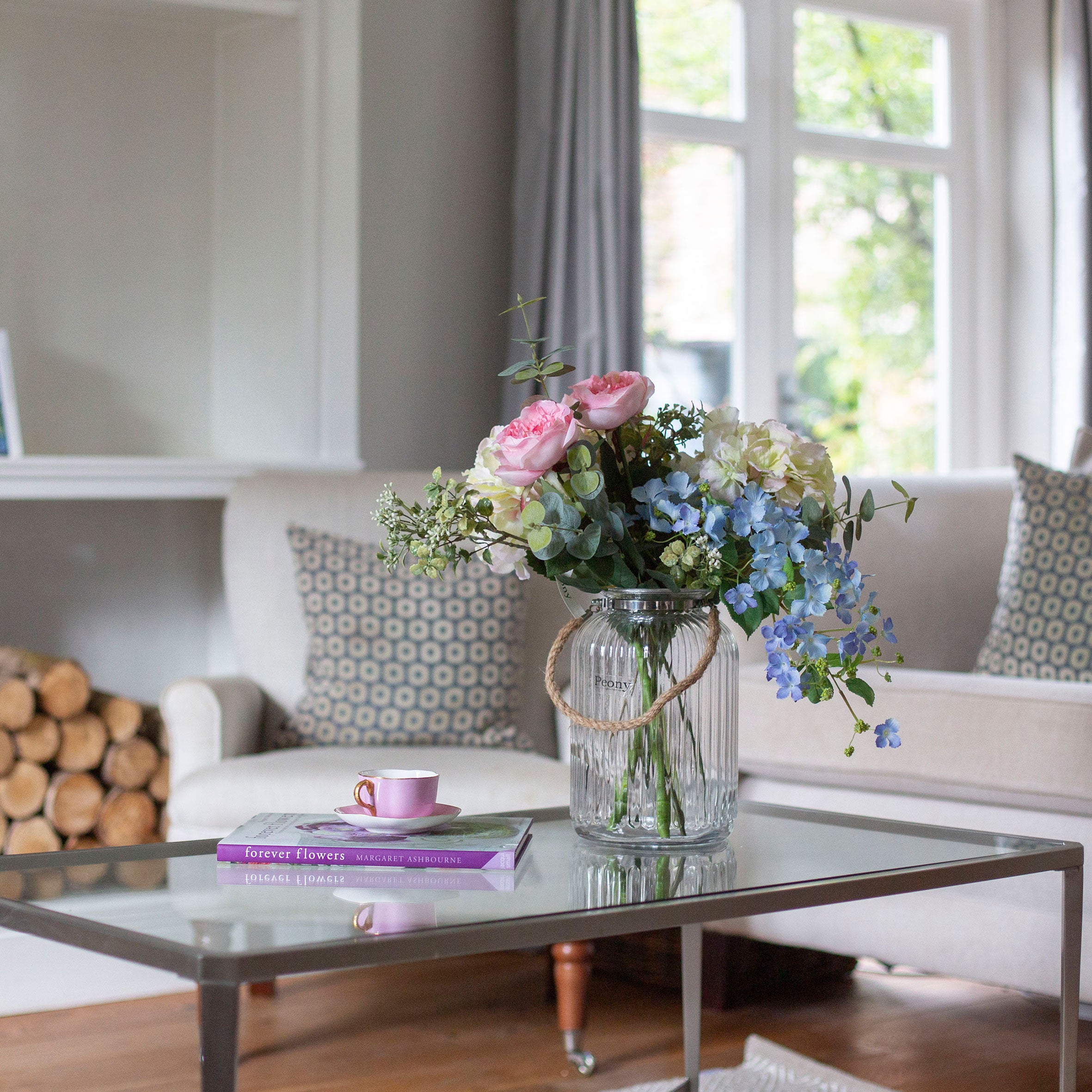 Artificial Country cottage style roses and hydrangea arrangement in a glass rope lantern vase