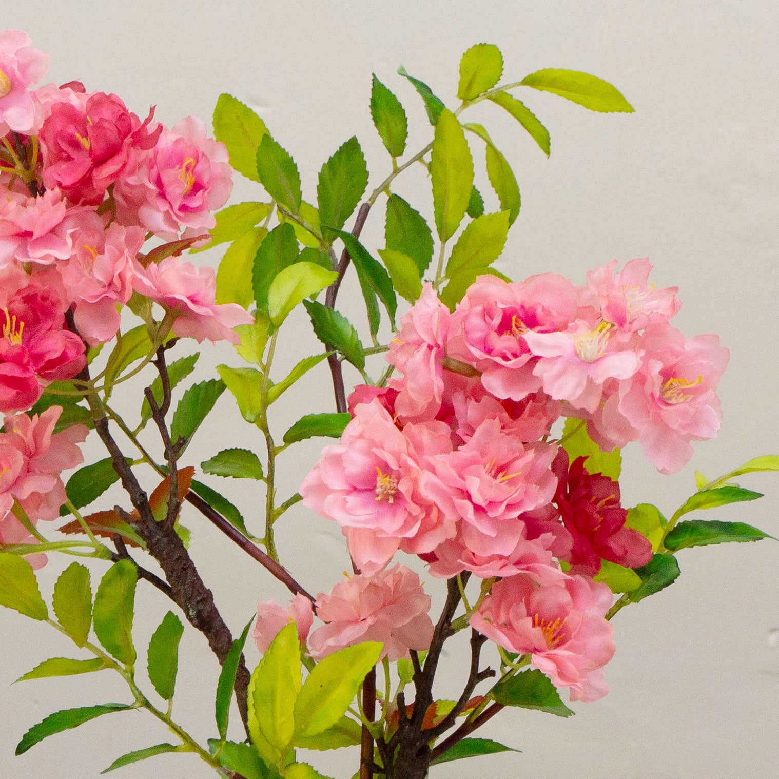 Artificial blossom stems arranged in a clear glass milk bottle vase