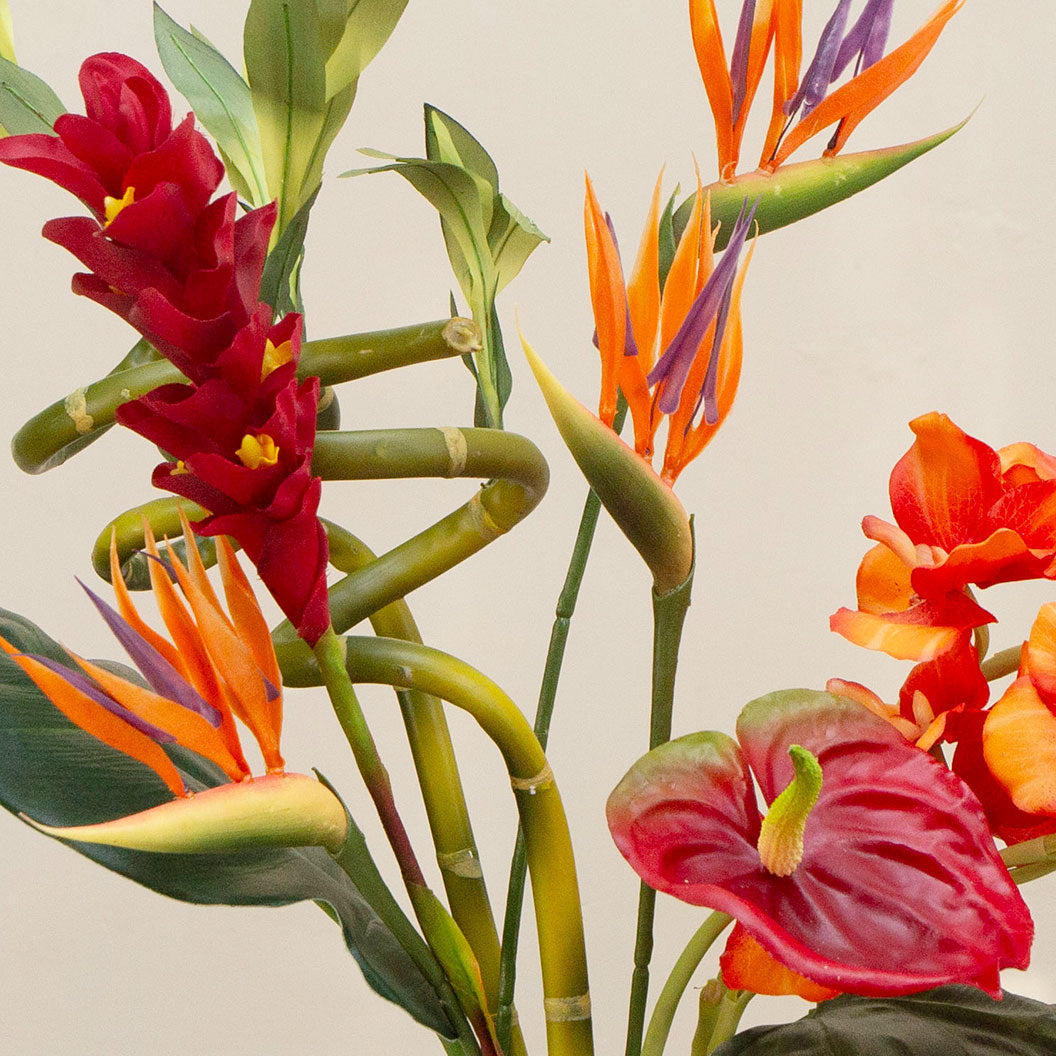Artificial t ropical flower arrangement with orchids and birds of paradise in a glass cylinder vase
