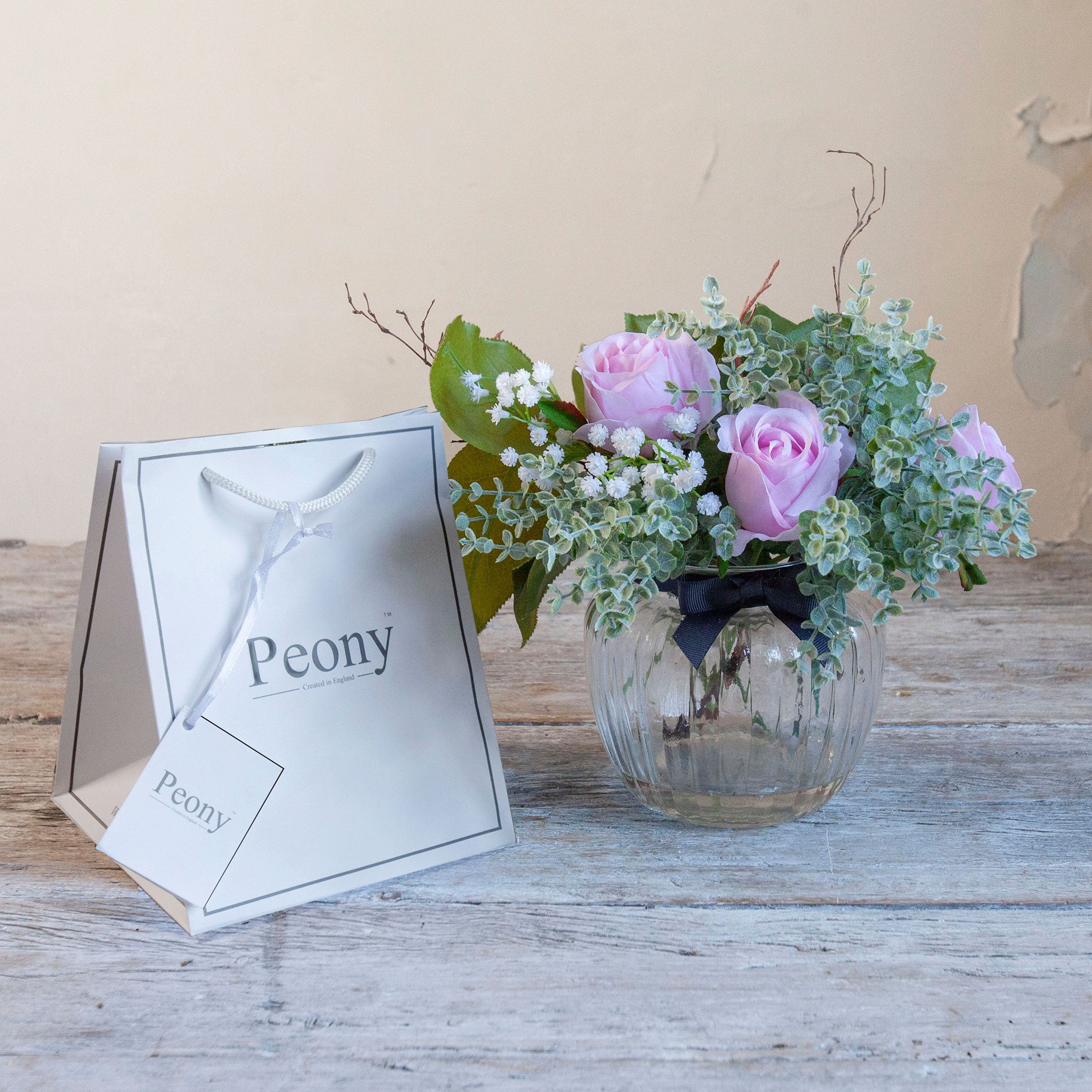Artificial pink roses, mini eucalyptus and gypsophila set in a clear optic glass jar vase with Peony gift bag.