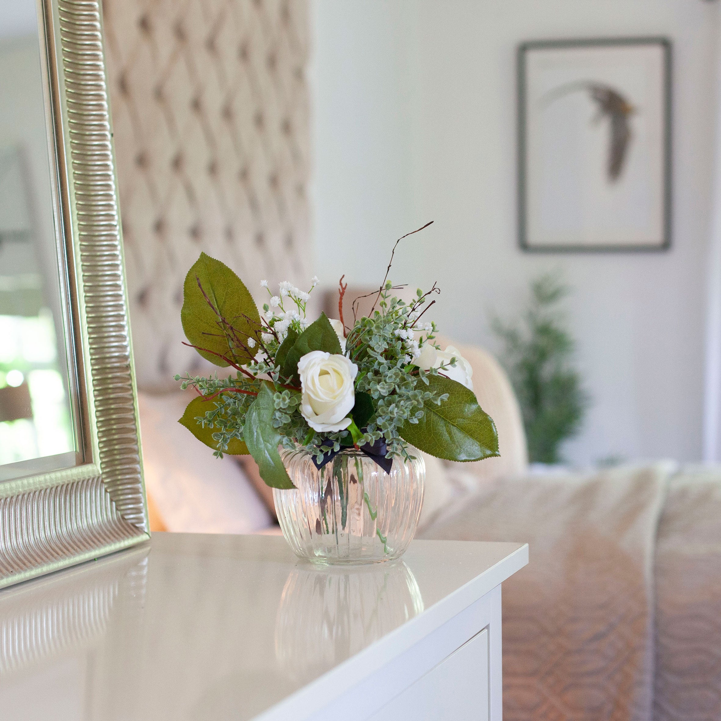 Artificial White Roses, Mini Eucalyptus & Gypsophila in Optic Jar Vase Gift Set, styled on a white console table in a softly lit neutral home interior.