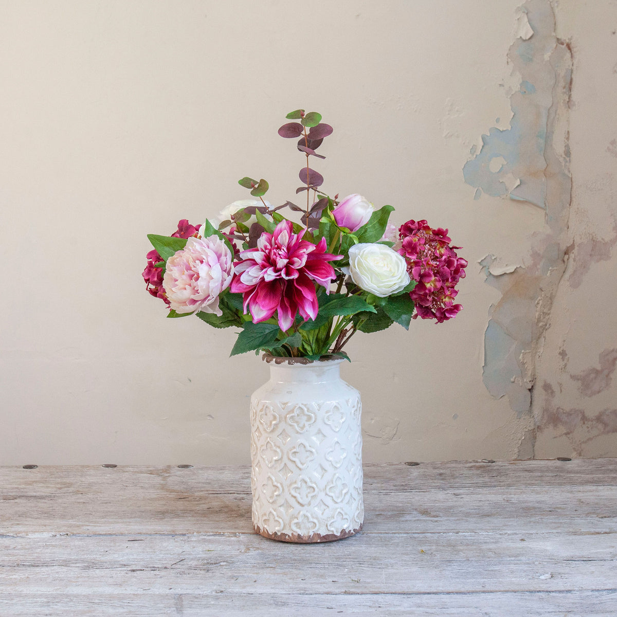 Artificial hydrangea, dahlia and peony bouquet in pink, burgundy and white tones, displayed in a white textured vase.