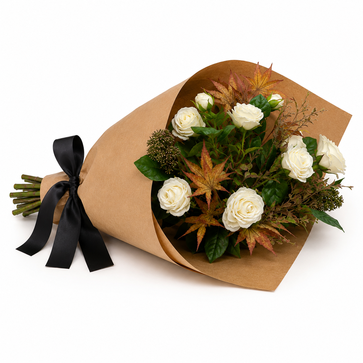 Artificial rose, ranunculus and autumn foliage bouquet with white flowers and warm seasonal leaves, wrapped in brown kraft paper with a black satin ribbon.