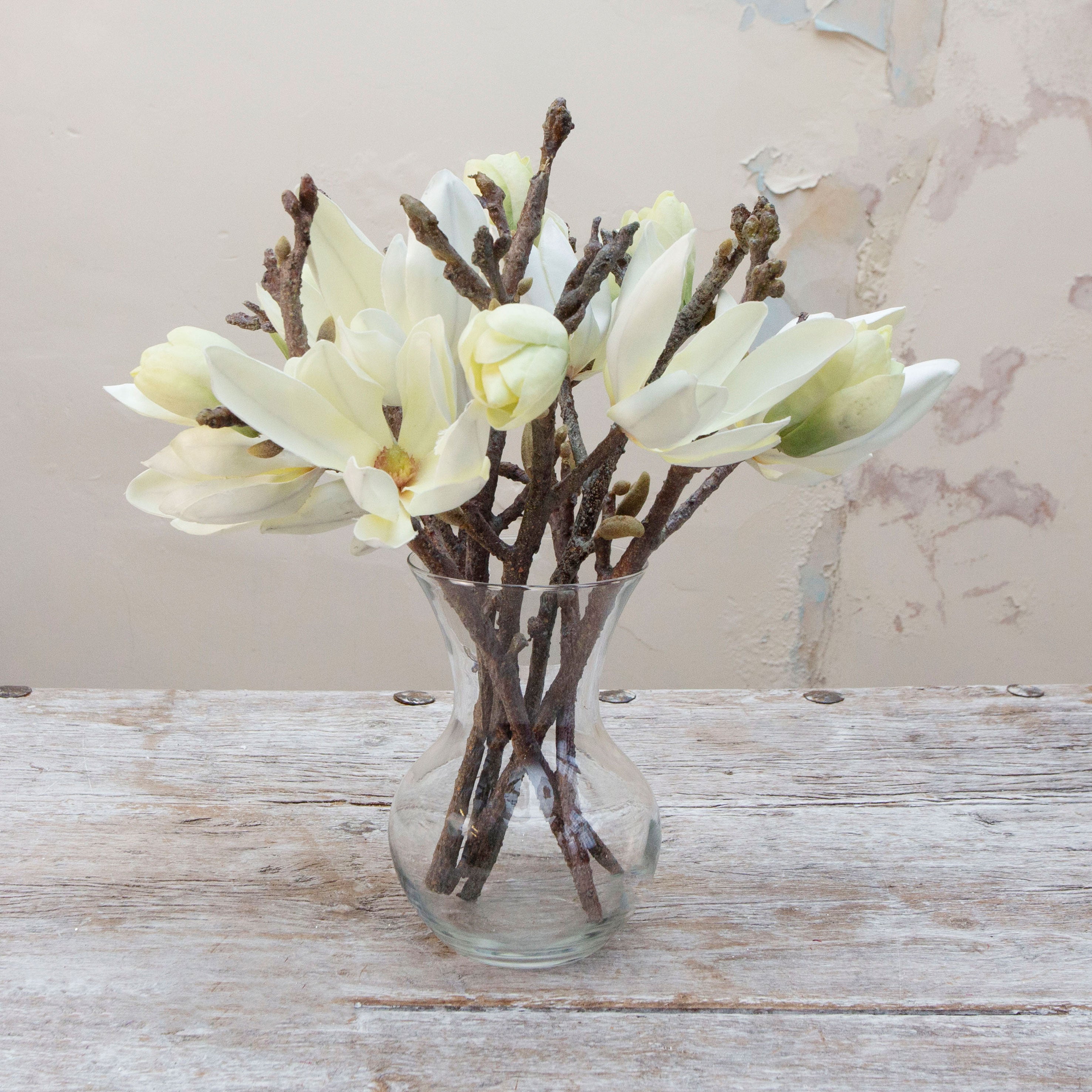 Artificial cream magnolia spray stems displayed together in a vase for styling purposes
