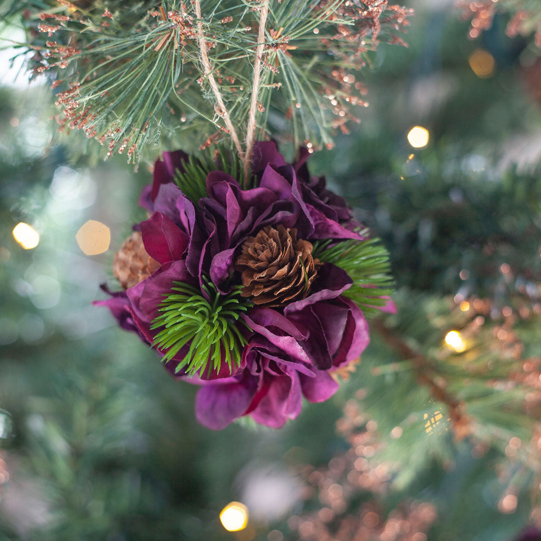 Close up of decorative artificial hanging ball with pine cones and purple hydrangea petals