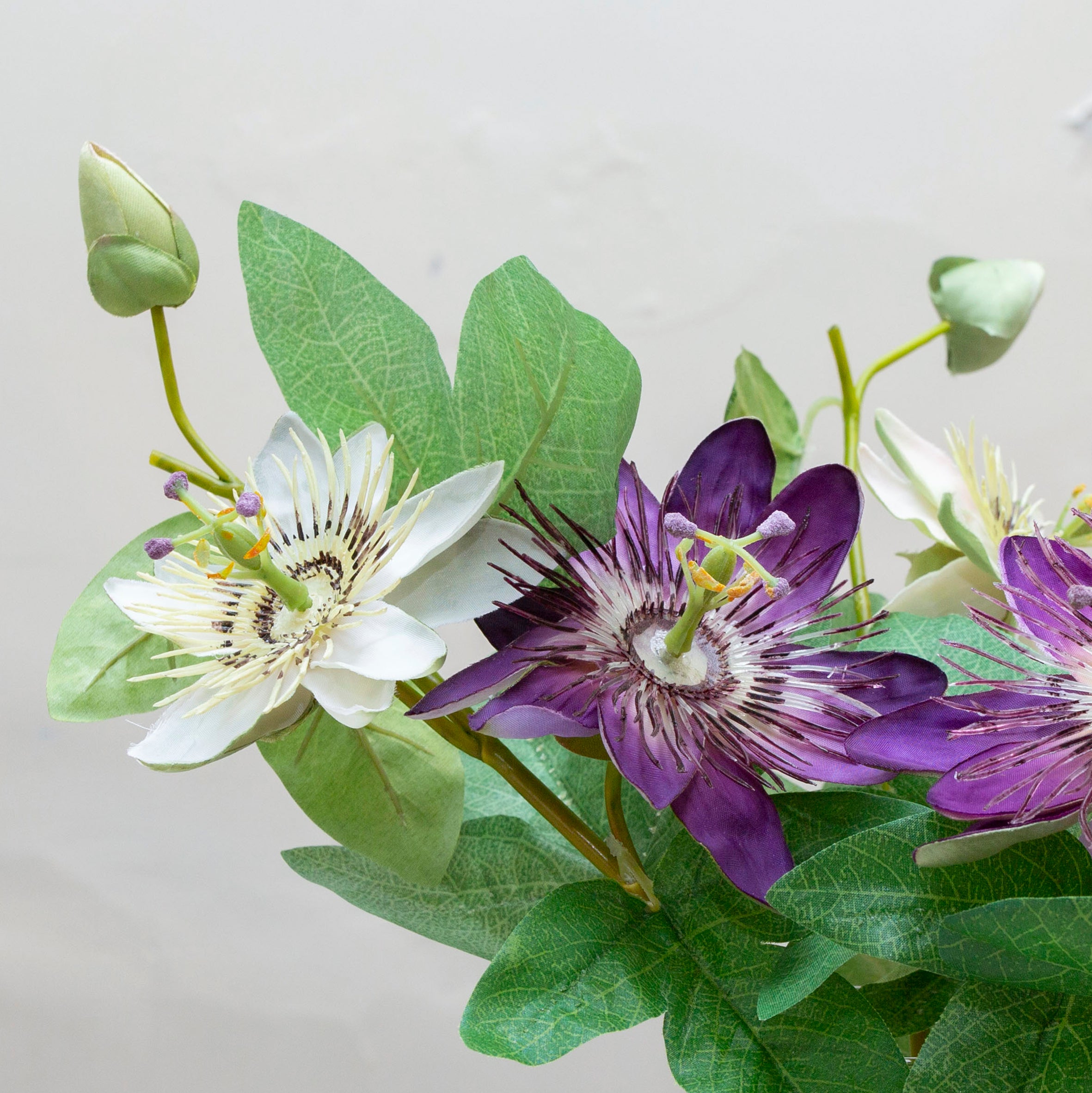 Close-up of artificial passion flower bloom showing detailed purple and cream petals with textured center