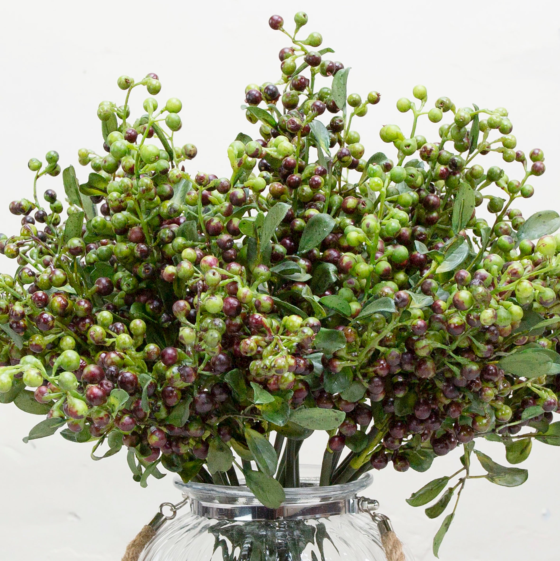 Close-up of artificial berry stem, highlighting green and deep berry-toned clusters with subtle colour variation, textured stems and finely detailed leaves for a realistic finish