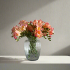 Artificial rose pink–peach orchid stem displayed in a vase, with realistic open blooms and delicate bud detail.