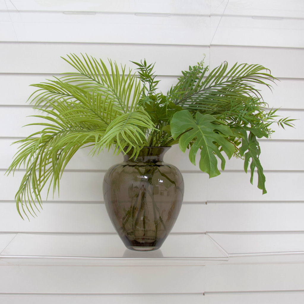 An abundance of beautiful artificial greenery in the smoked sweetheart vase.