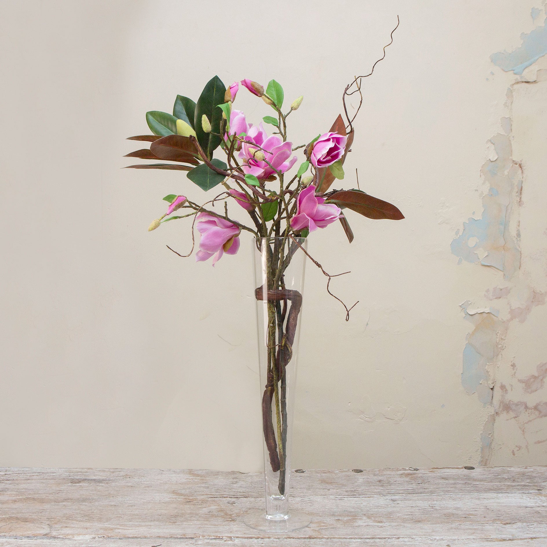 Artificial magnolia arrangement with contorted willow in a tall Conical Vase
