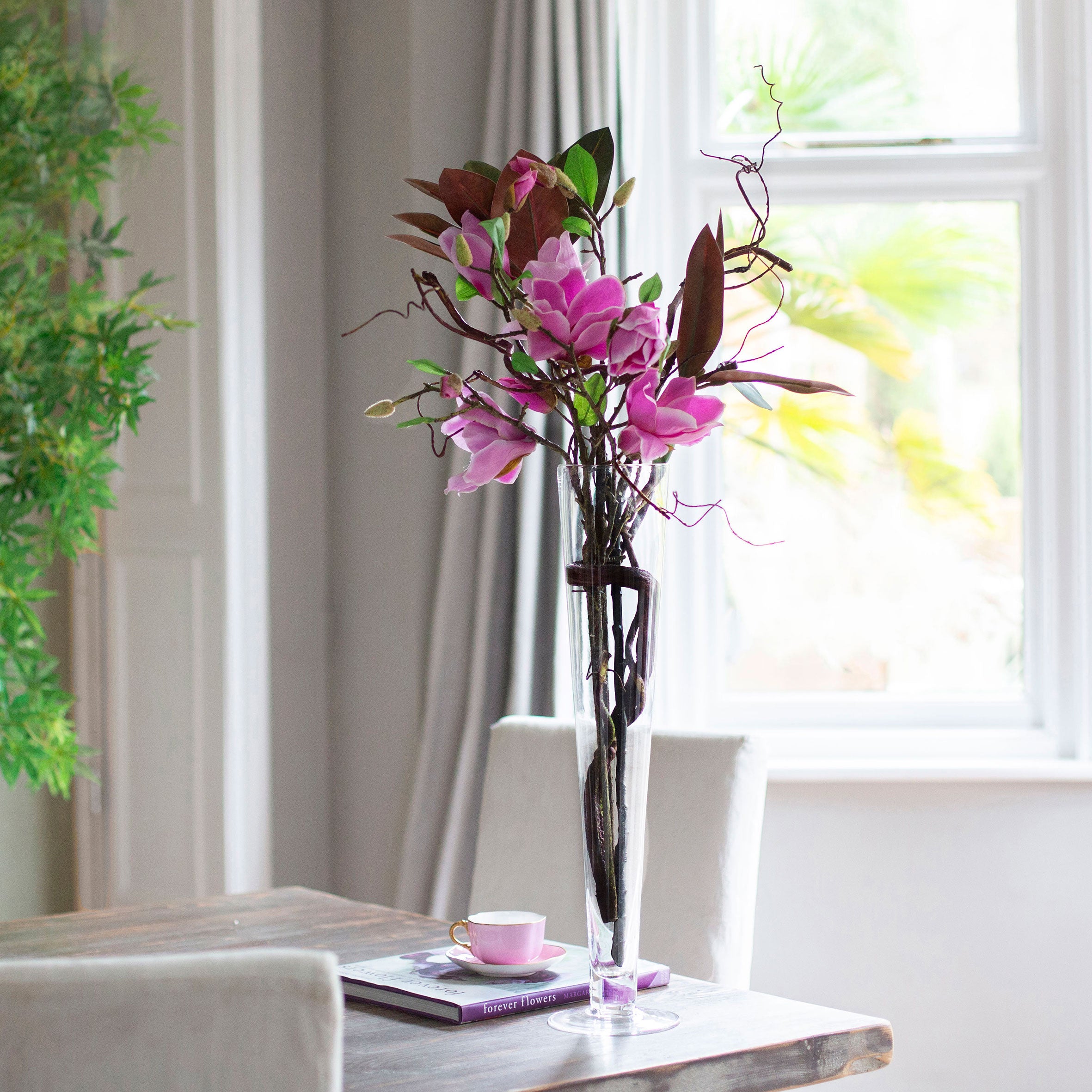Artificial magnolia arrangement with contorted willow in a tall Conical Vase