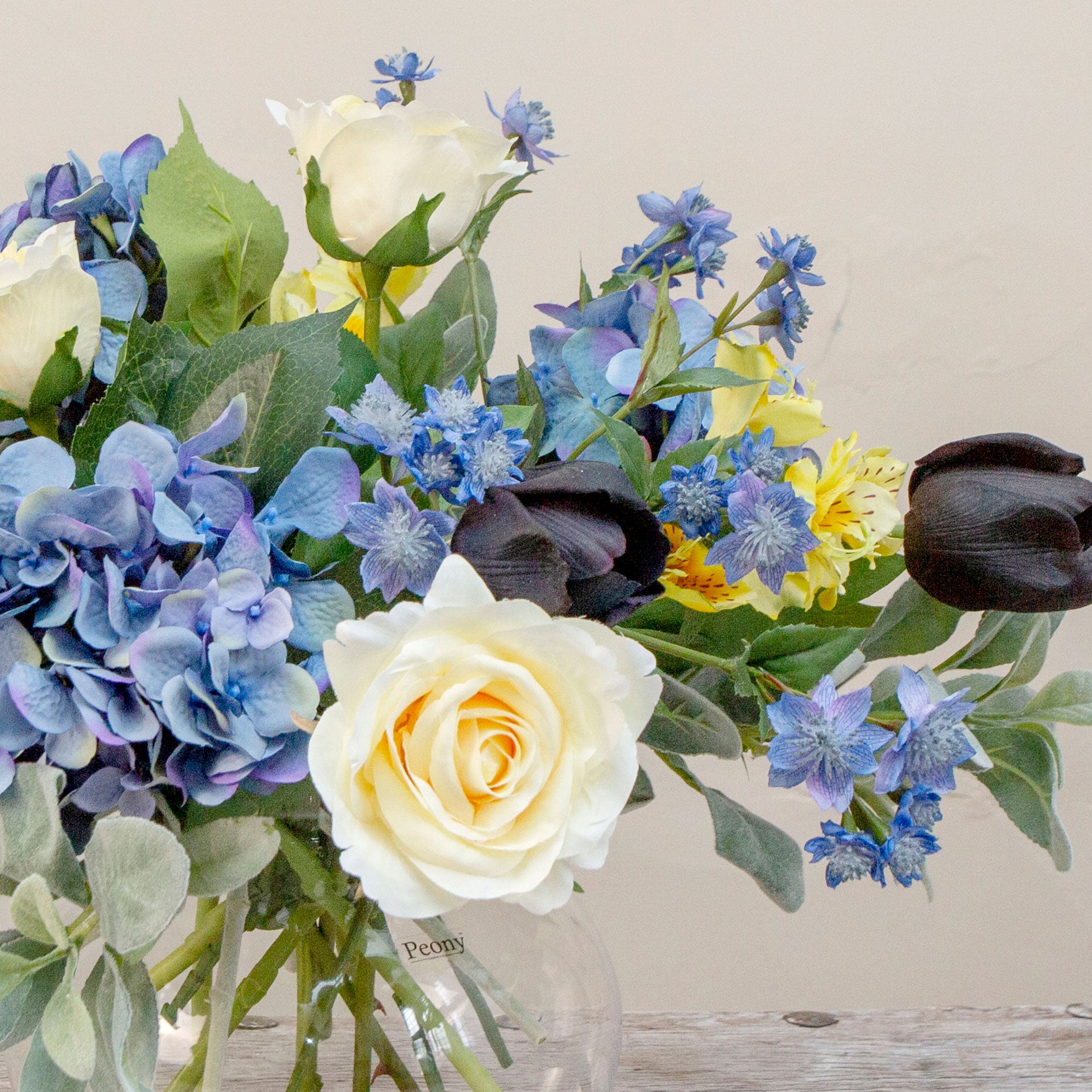Artificial blue and yellow floral bowl arrangement with Roses, Hydrangeas and Tulips