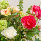 Artificial peach and lemon floral arrangement in a clear glass vase with roses, peonies, honeysuckle and viburnum