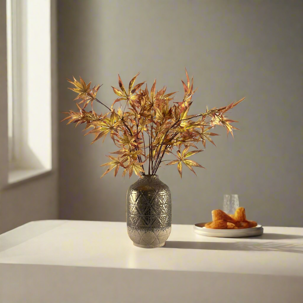 Artificial Japanese maple leaf stems displayed in decorative vase for styling purposes only