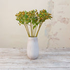 Artificial Yoshino berry stem displayed in a vase, with realistic green berry clusters and soft foliage adding natural texture and height