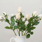 Close-up of artificial open  rose buds showing soft blush and cream petals with natural colour variation
