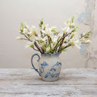 Artificial bridal white magnolia blossom spray stems displayed together in a vase for styling purposes.