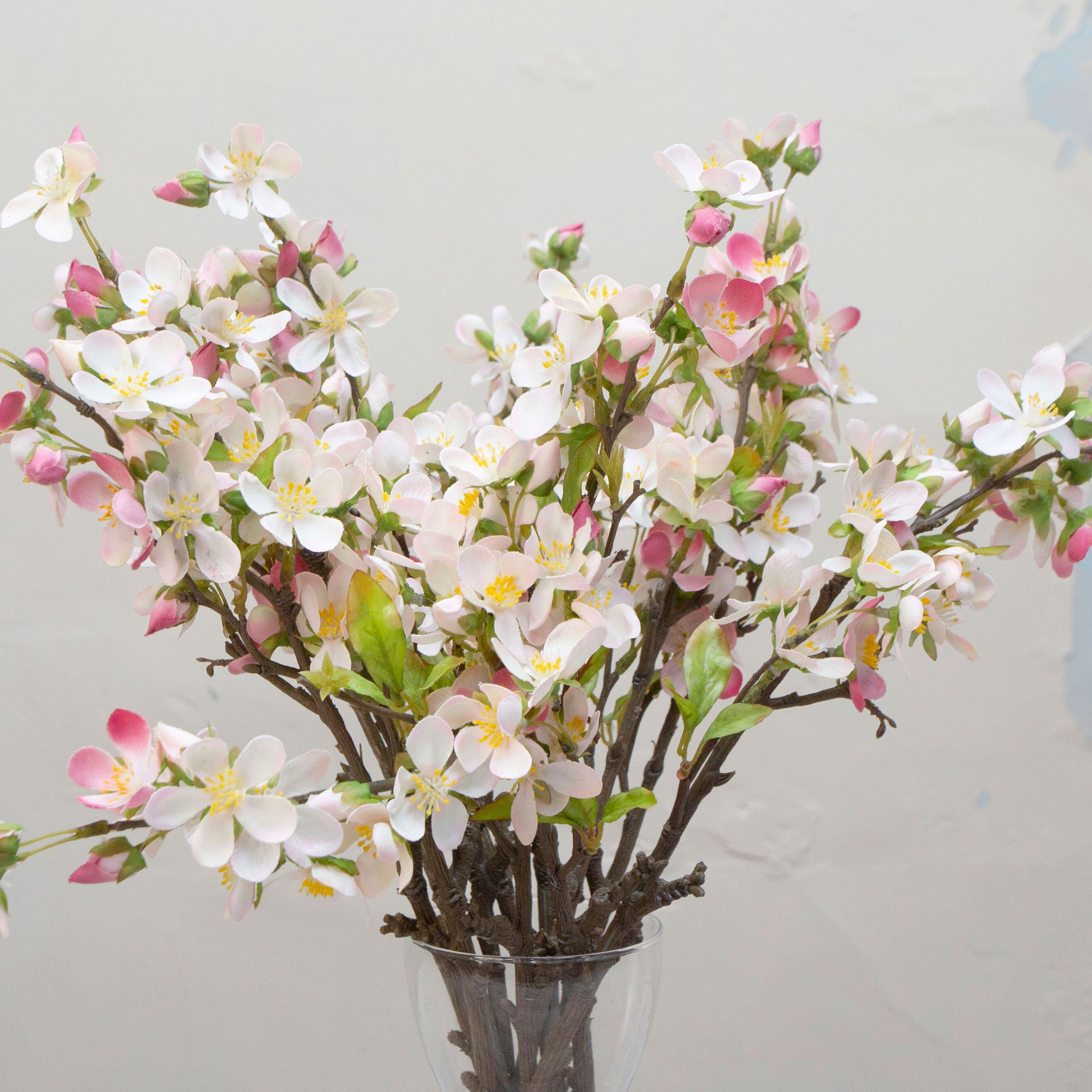 Close-up of artificial light pink blossom flowers showing delicate petals and yellow centres.