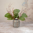 Artificial green salal leaf stems with delicate brown branches displayed in a textured metallic vase