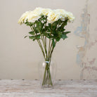 Artificial cream open sophia rose stems displayed together in a clear glass vase for styling purposes