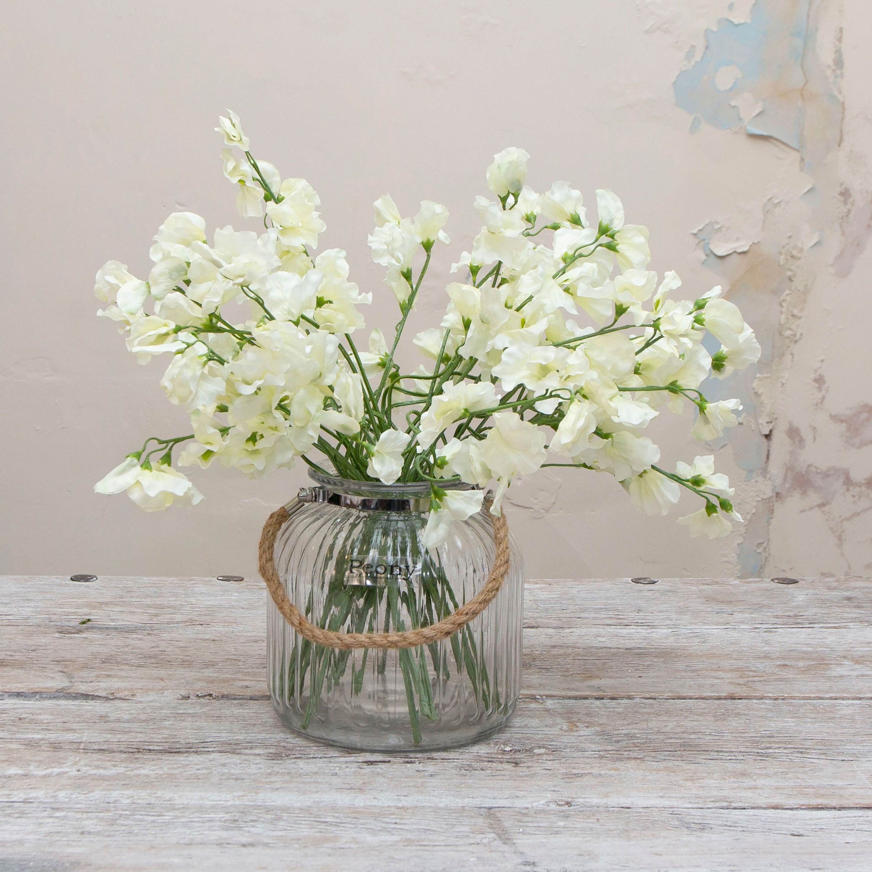 Artificial bridal white sweet pea stems displayed together in a vase for styling purposes