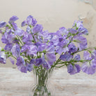 Close-up of artificial lavender-blue sweet pea flowers showing soft petals and gentle purple colour variation
