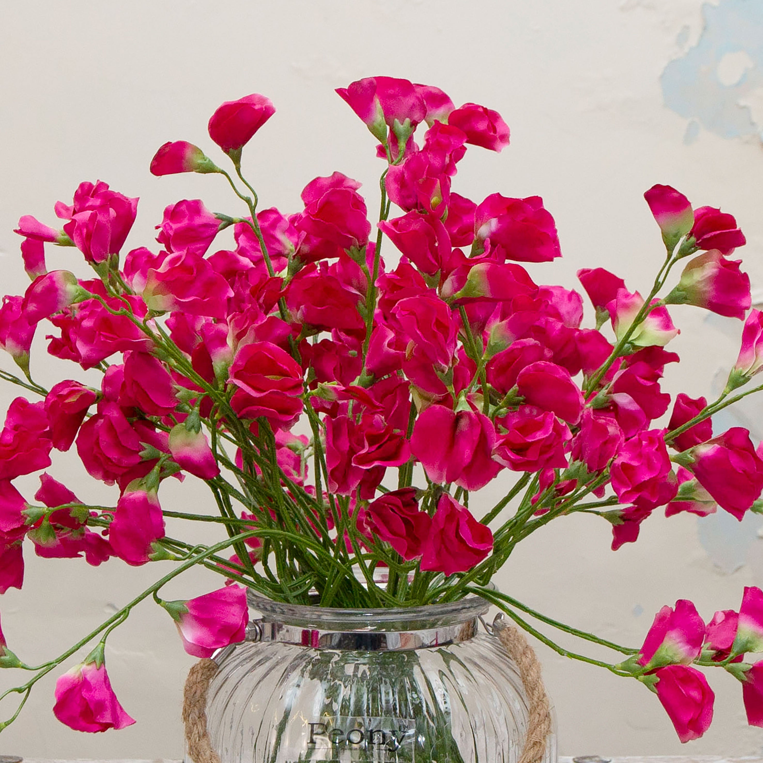 Close-up of artificial fuchsia sweet pea flowers showing soft petals and vibrant fuchsia colour detail
