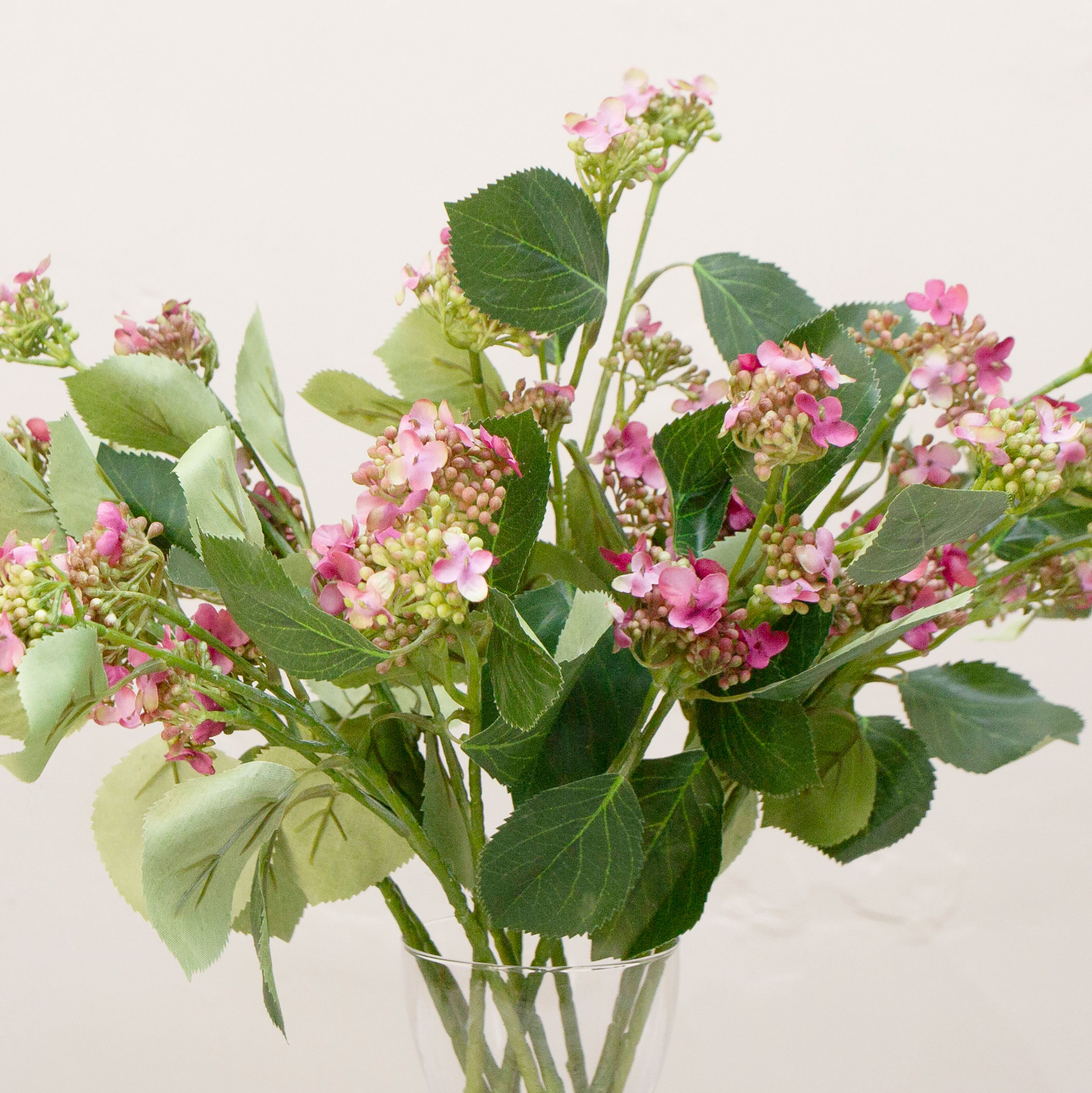 Close-up of artificial pink viburnum flowers, highlighting soft pink buds, subtle tonal variation and detailed leaf texture.