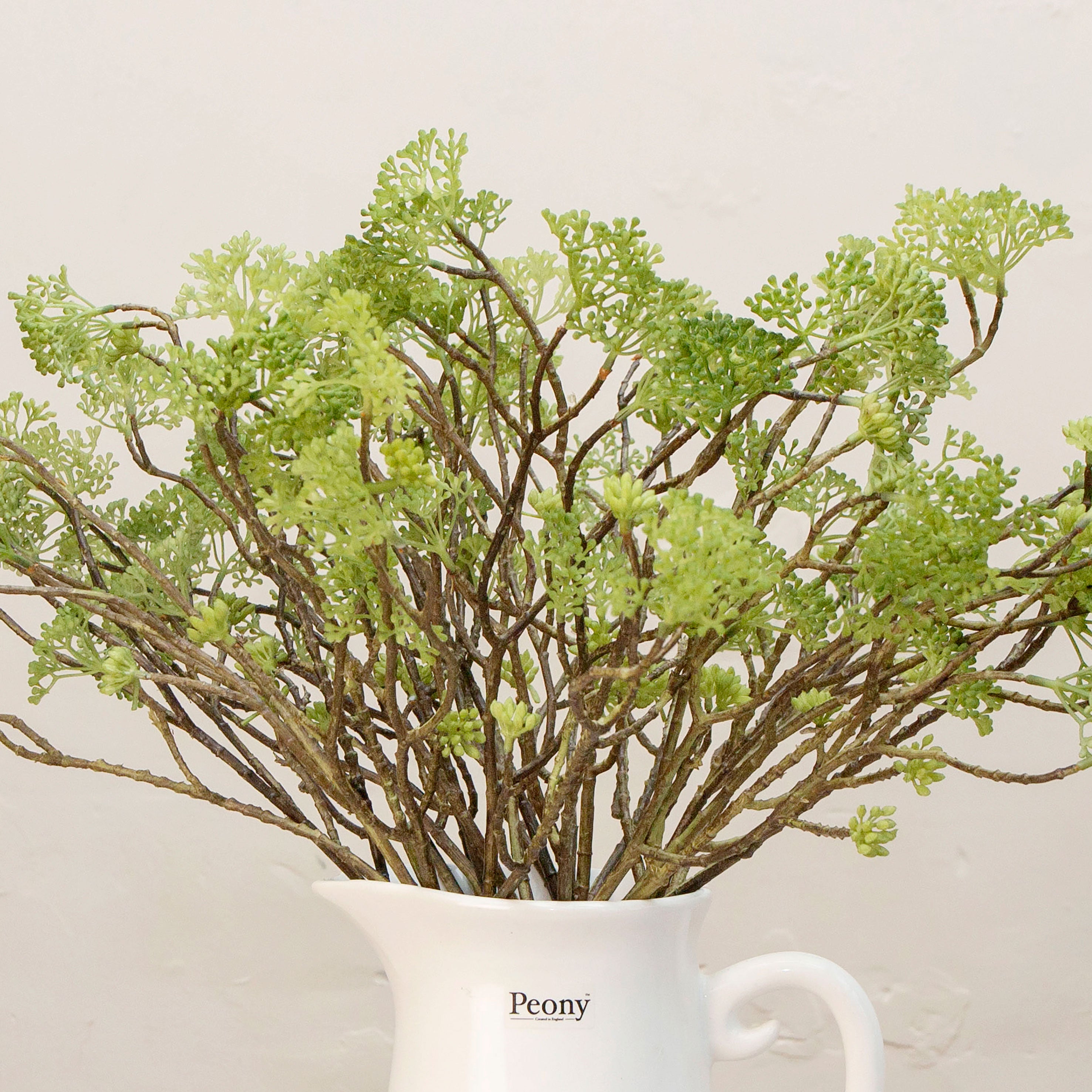 Close-up of artificial wild greenery foliage spray showing detailed leaves and natural texture.