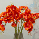 Close-up of artificial orange vanda orchid flowers showing vivid colour and petal detail.